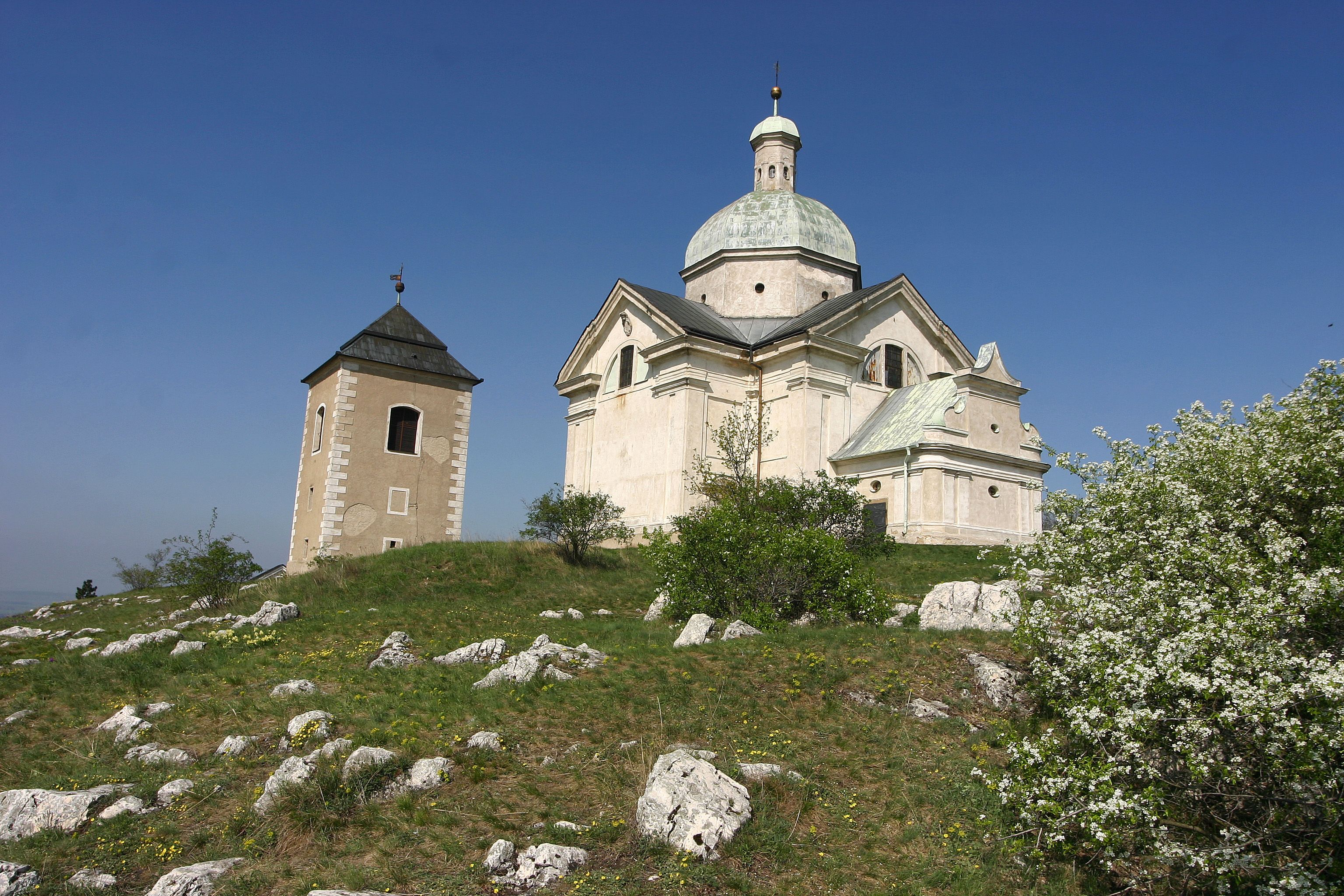 Chapel on a hill with blue sky in the background.
