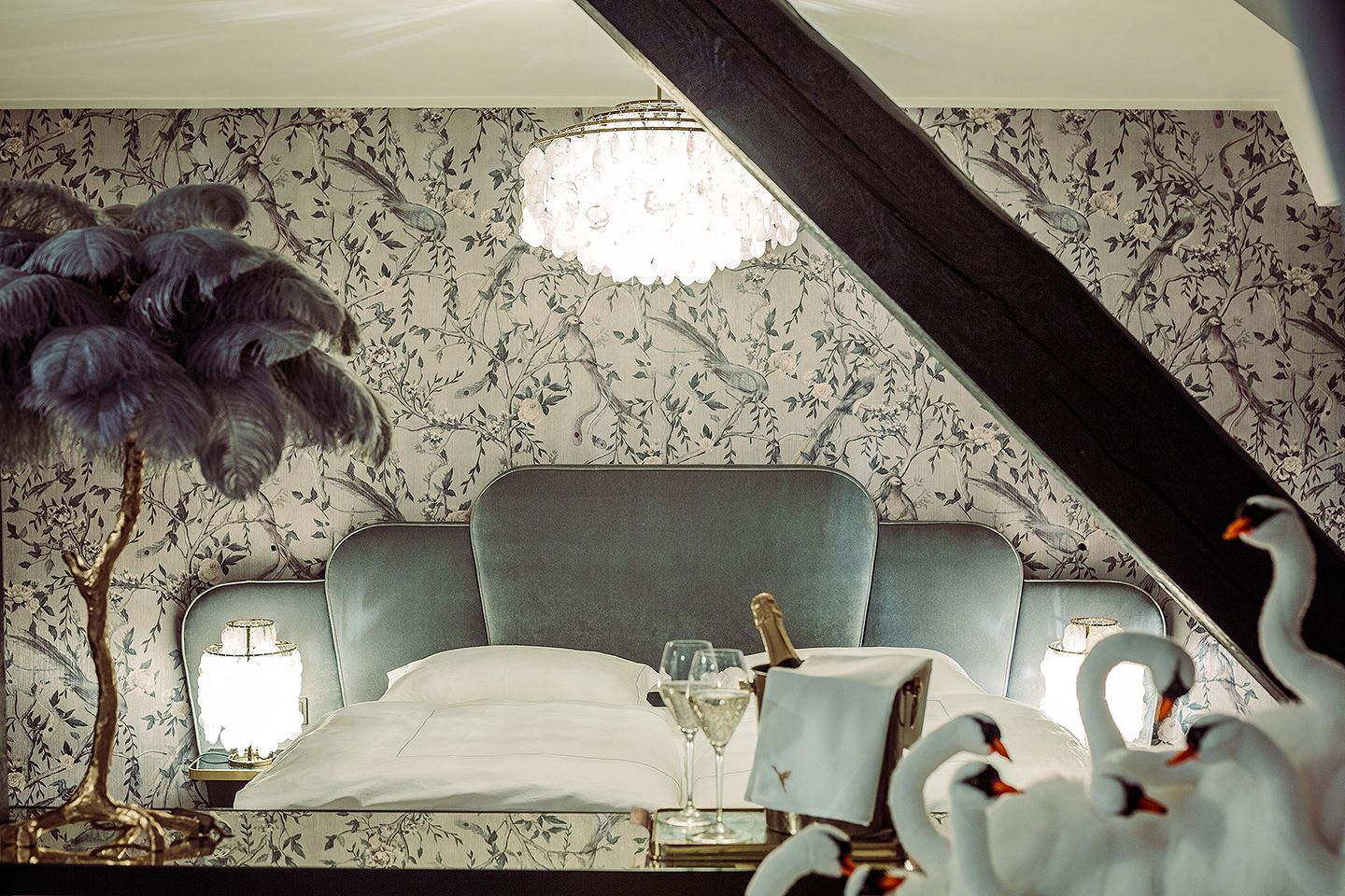 Elegant bedroom with luxurious bed, chandelier and decorative swans.