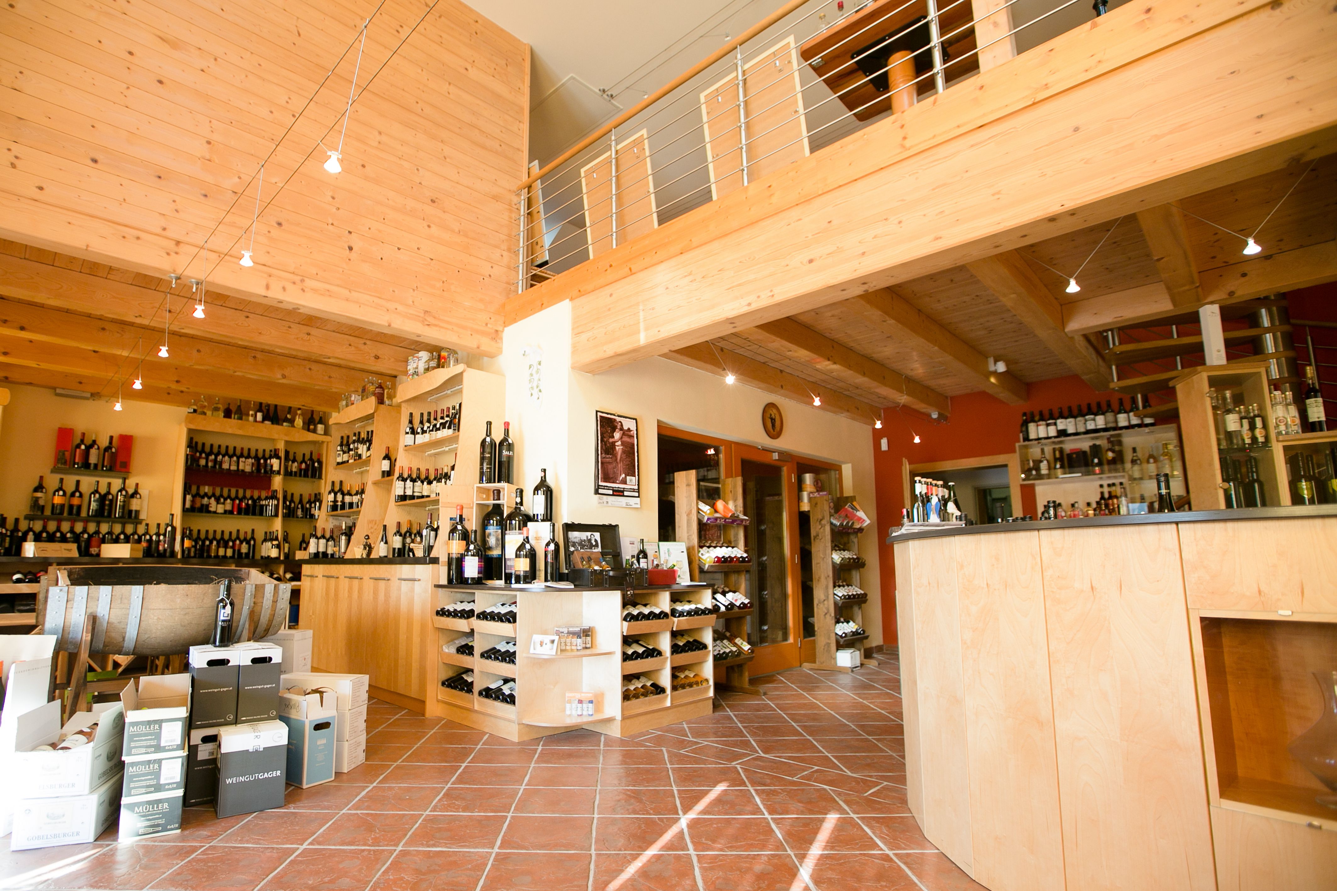 Interior view of a wine shop with wooden furnishings and wine bottles.