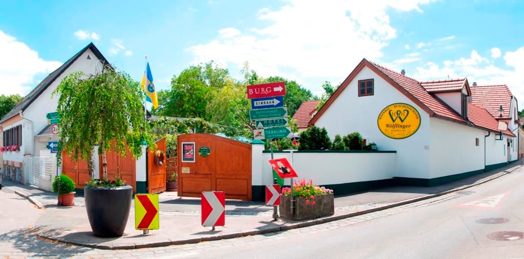 Entrance to the Wölflinger winery with signs and plants.