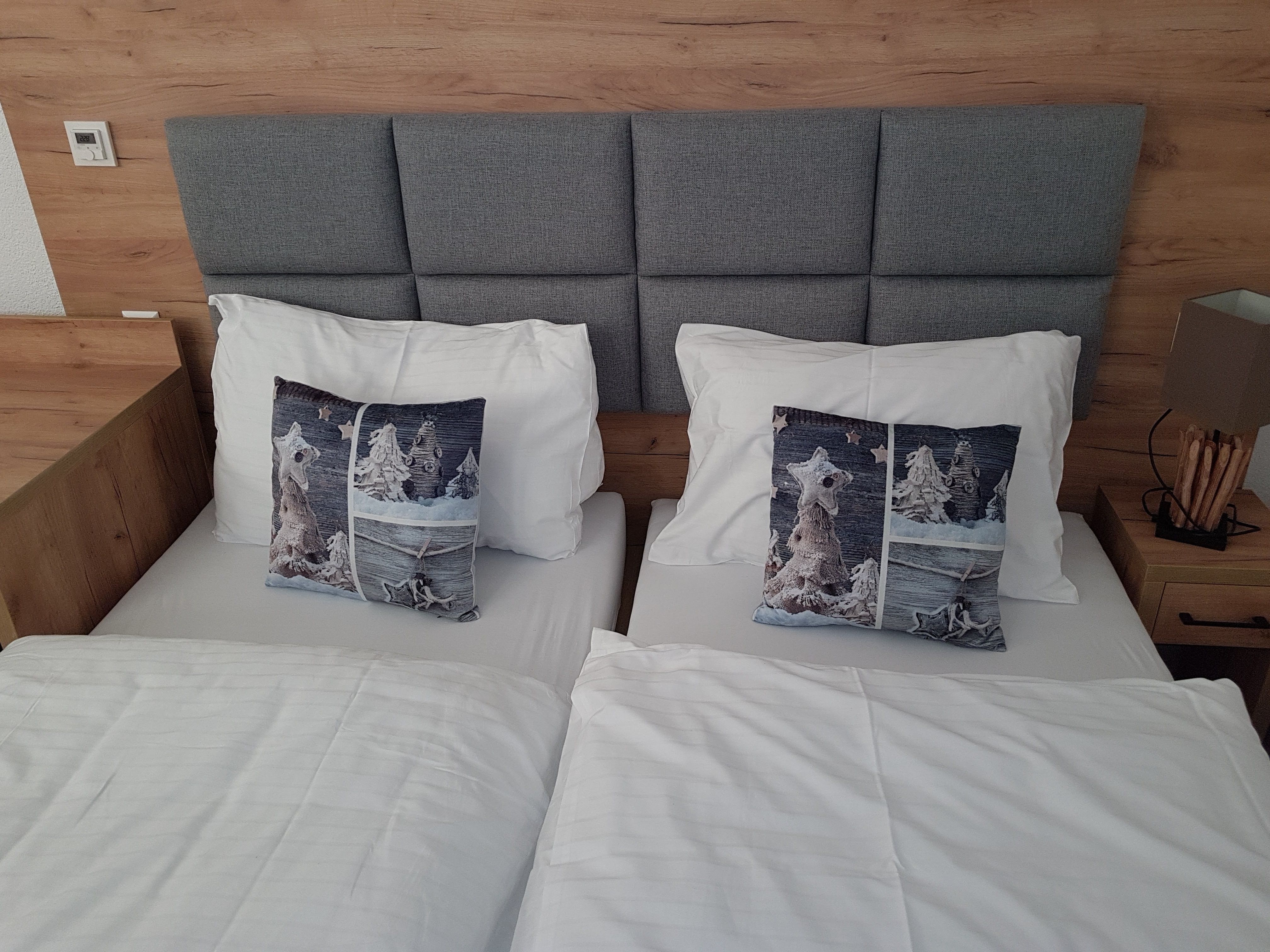Double room with two single beds, gray headboard, gray pillows and white bed linen