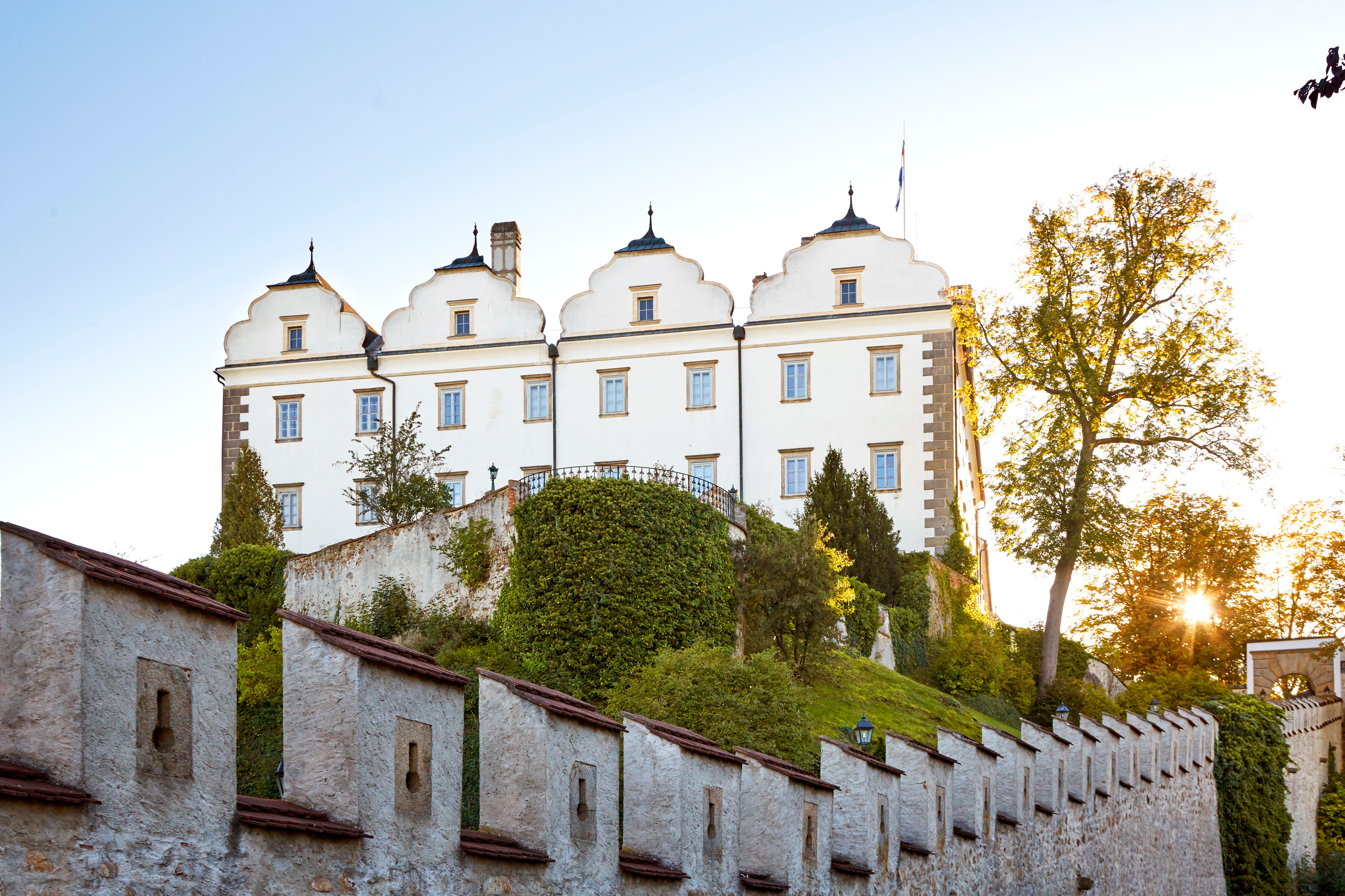 Aerial view of Weitra Castle in Austria at sunset, surrounded by green landscape and trees.