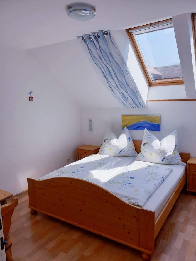 Bright bedroom with wooden bed, skylight and blue decoration.