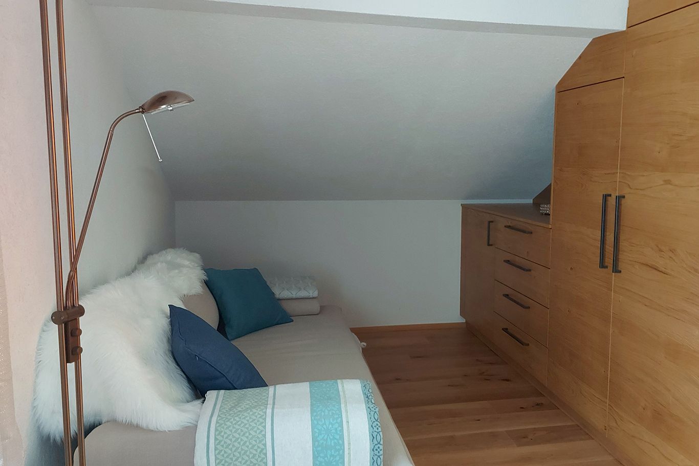 Double room on the upper floor with pull-out couch, wooden floor and wardrobe.