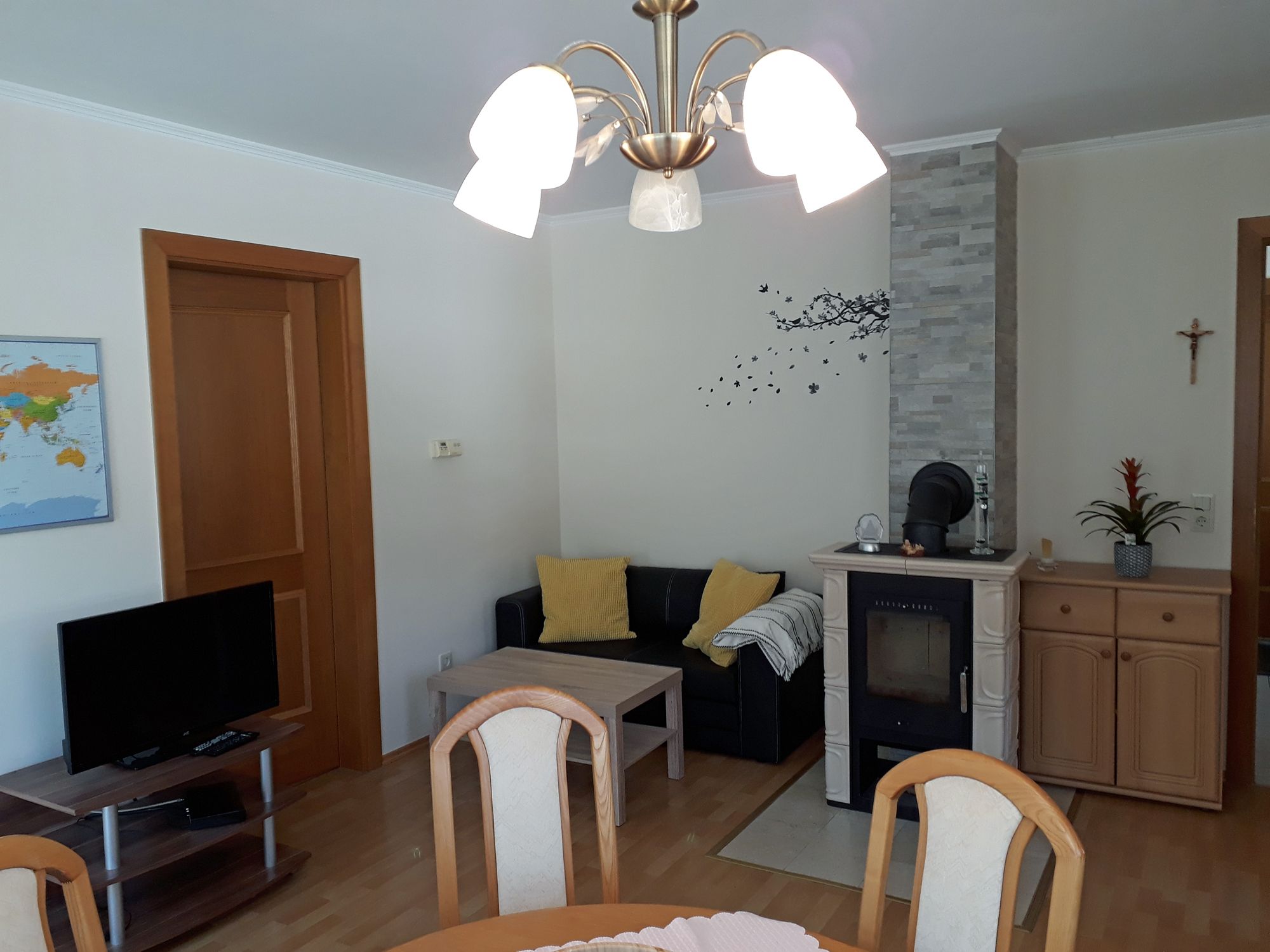 Living room with fireplace, sofa, table and TV.