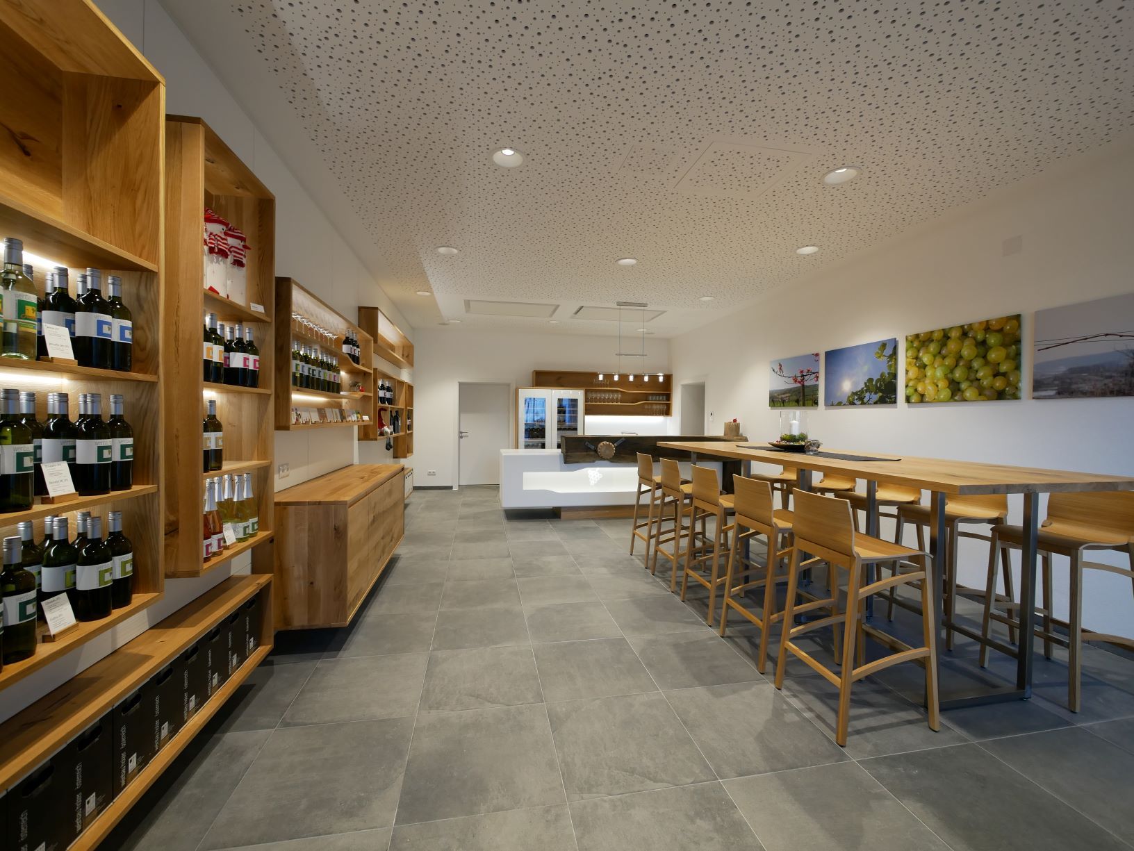 Modern tasting room with wooden furniture and wine racks.