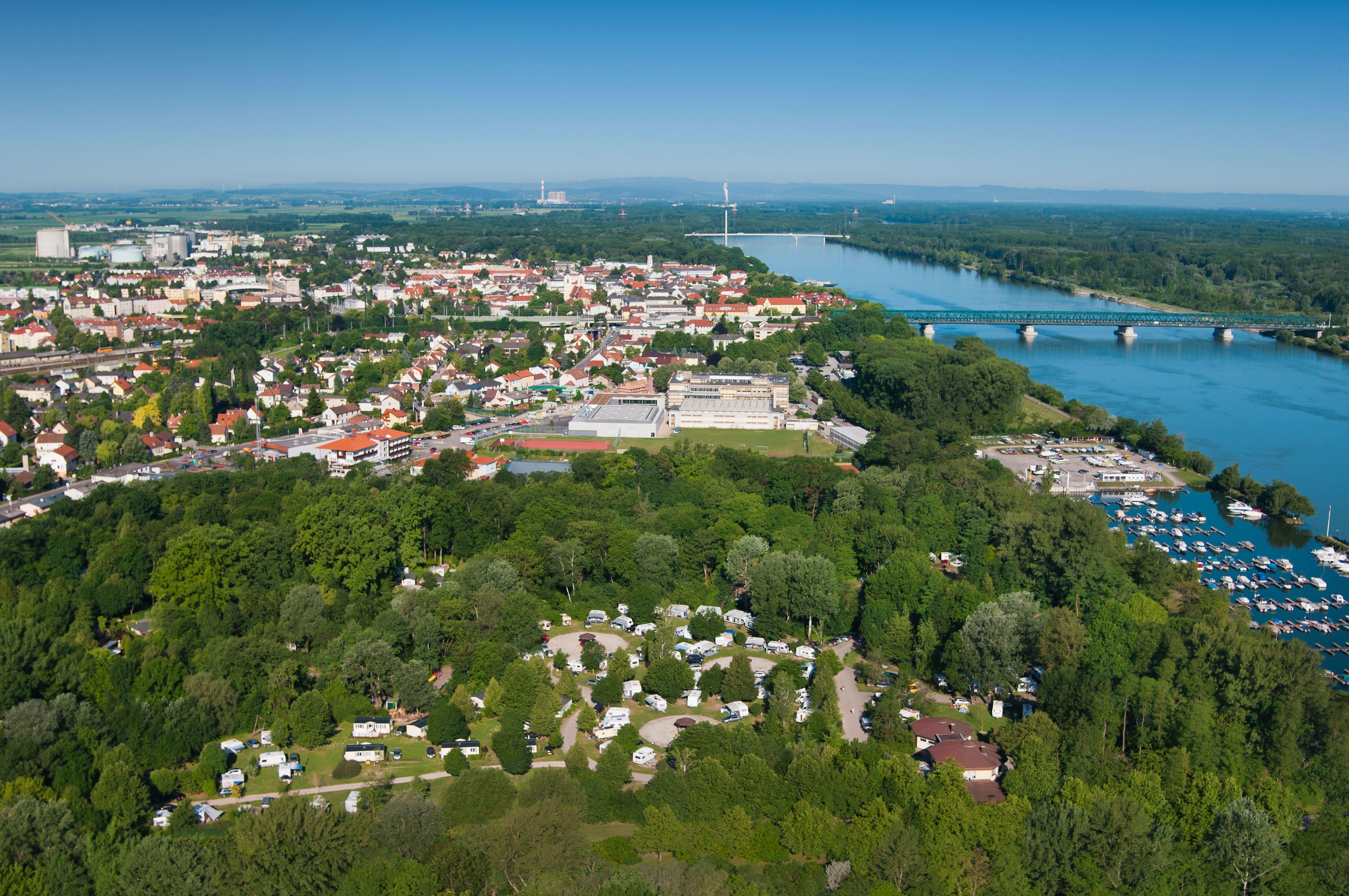 Aerial view of a campsite in Tulln on the Danube with the river and town in the background.