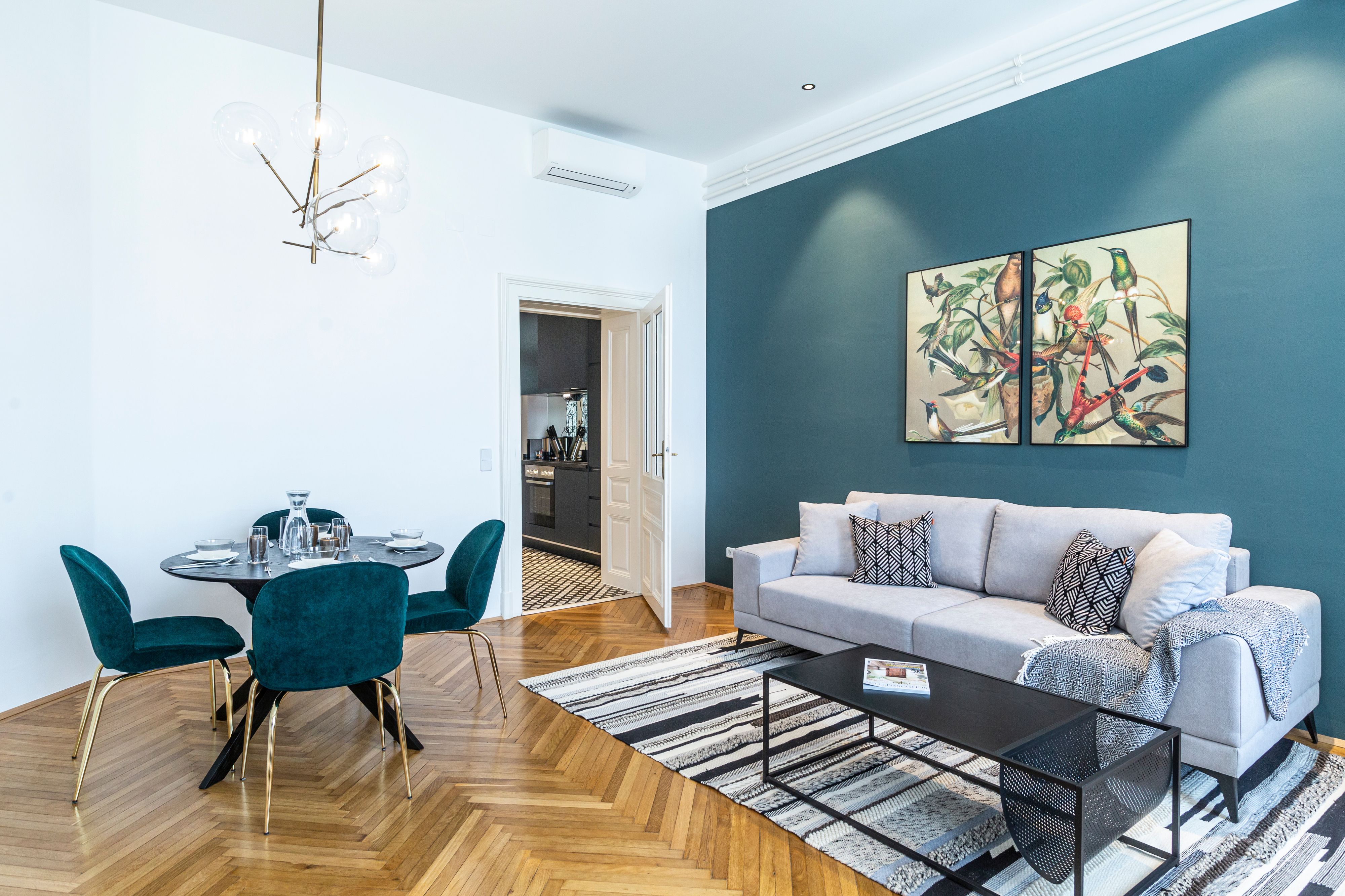 Modern living room with gray sofa, dining table and art on the wall.