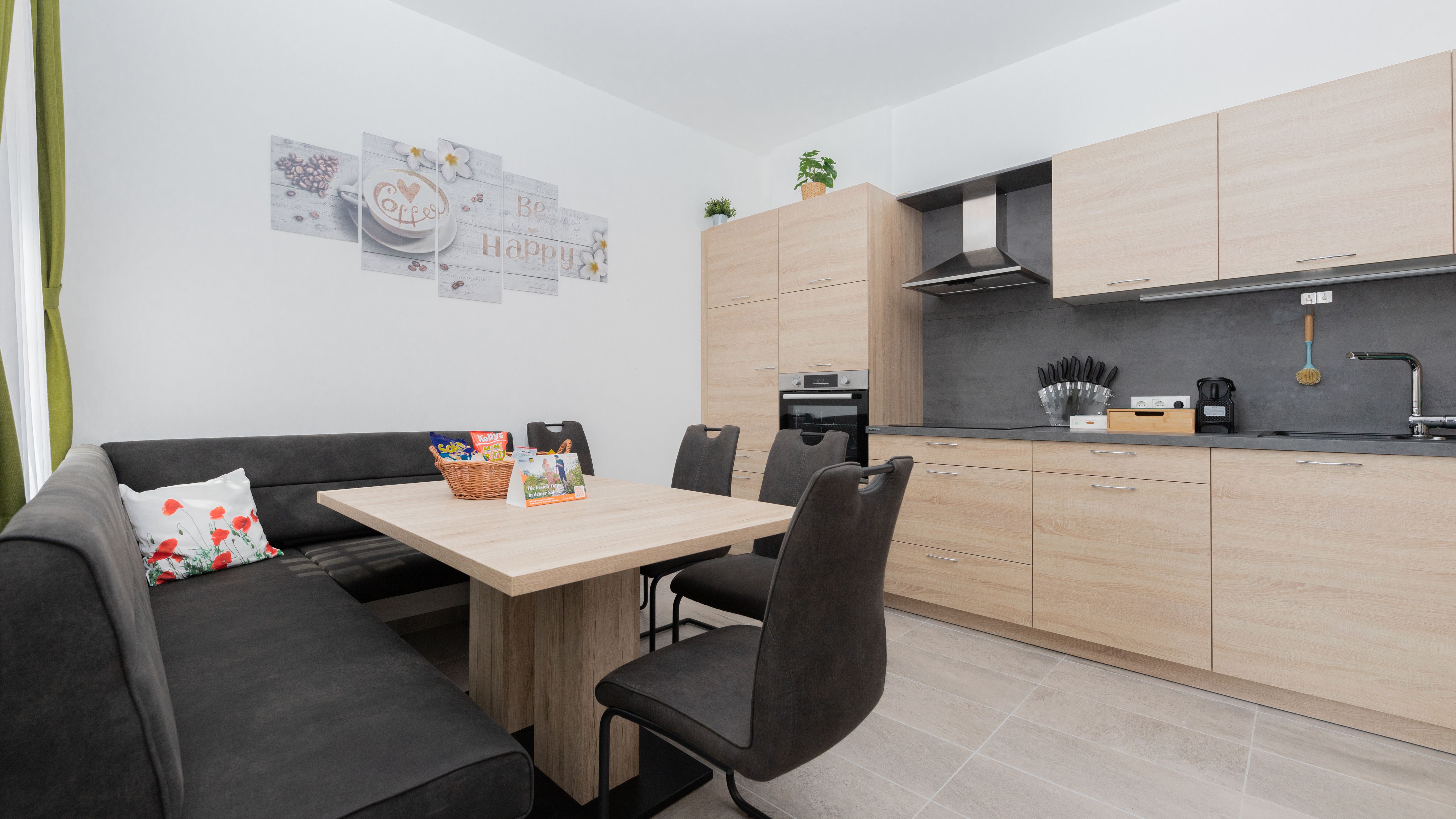 Modern kitchen with wooden furniture, dining table, corner bench and chairs.