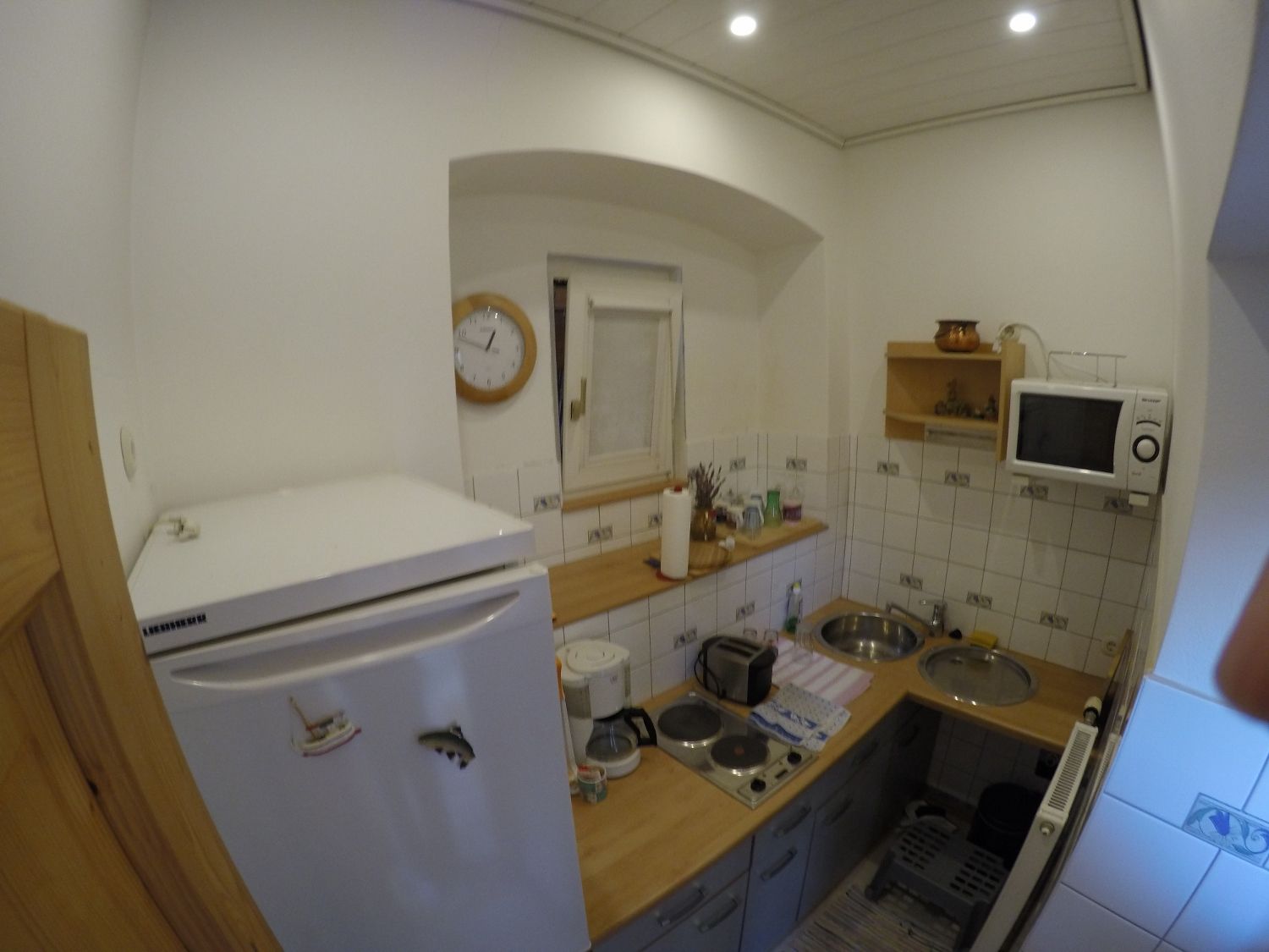 Small kitchen with fridge, microwave, stove and sink.