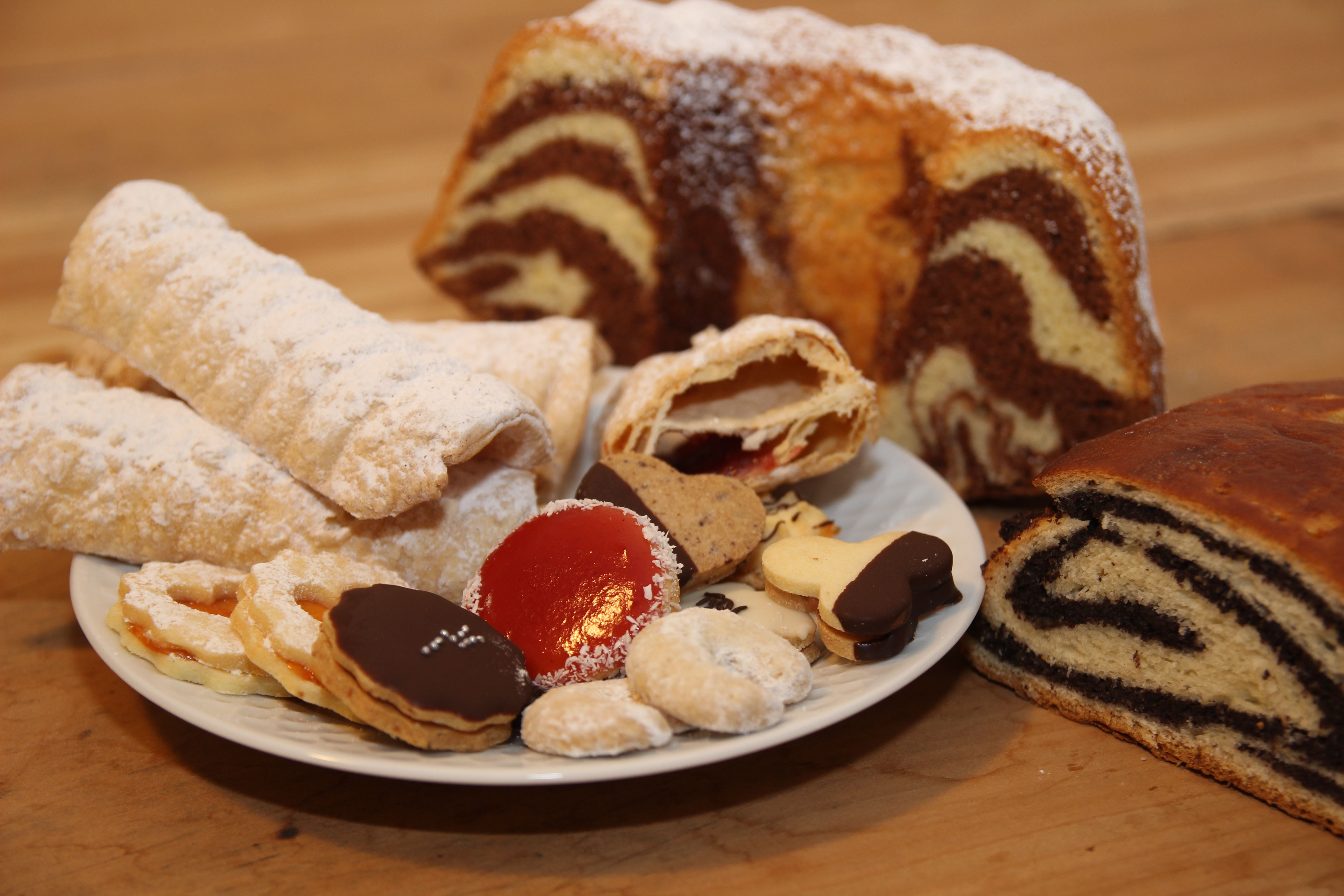 Various types of pastries on a plate, including cookies, strudel and marble cake.