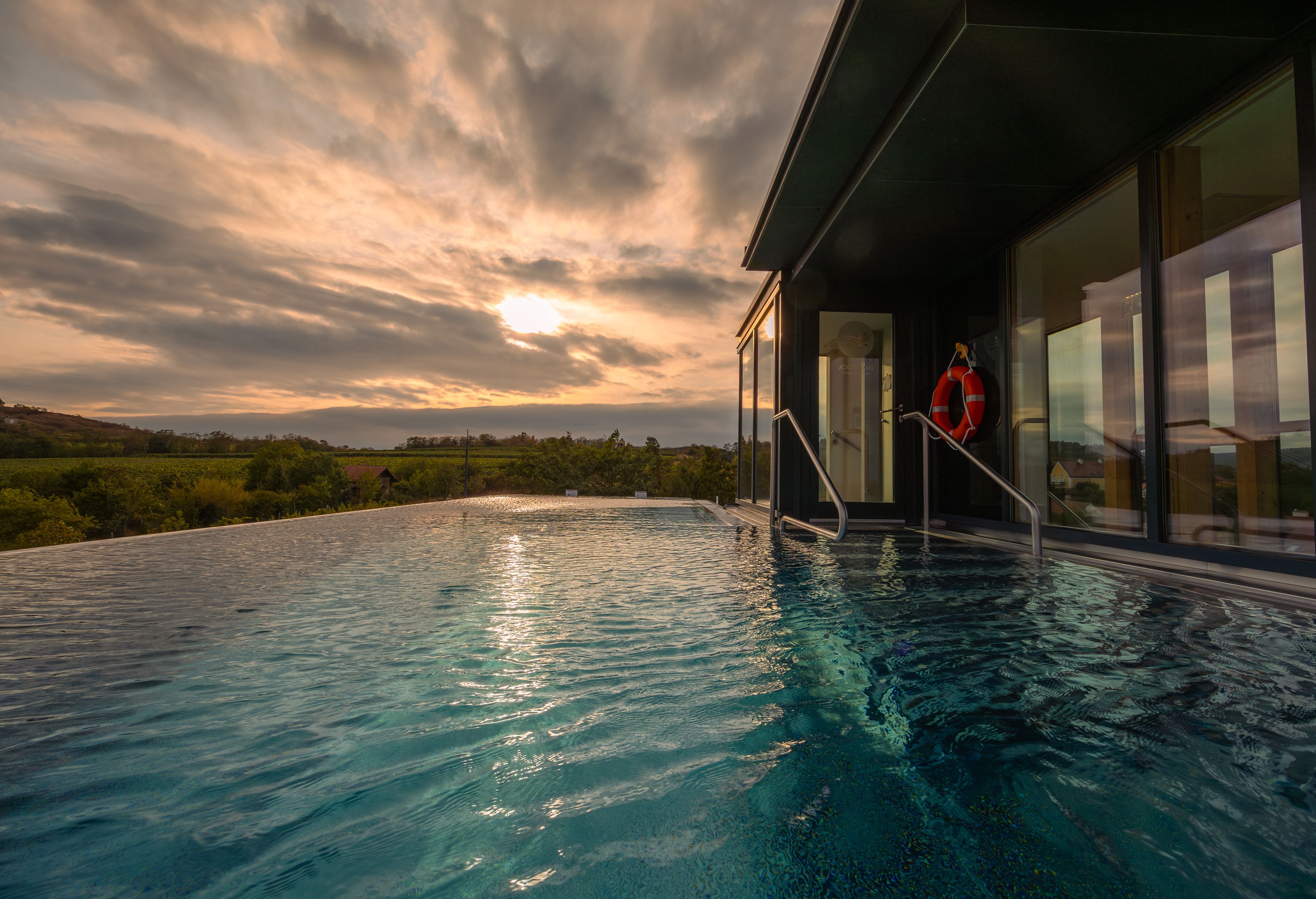 Infinity pool with a view of the landscape at sunset.