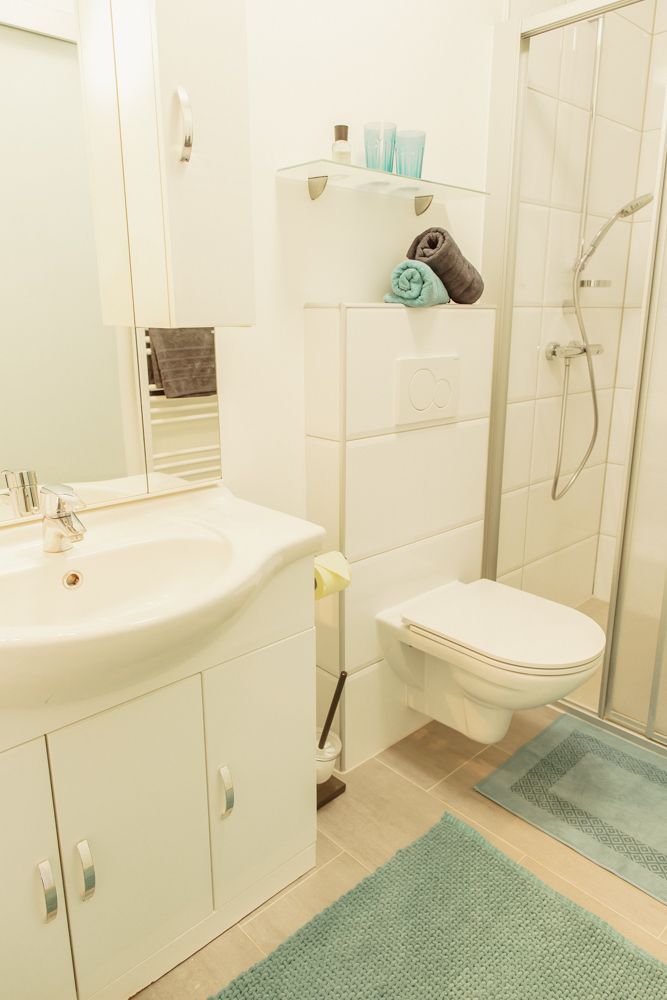 Modern bathroom with shower, washbasin and toilet.