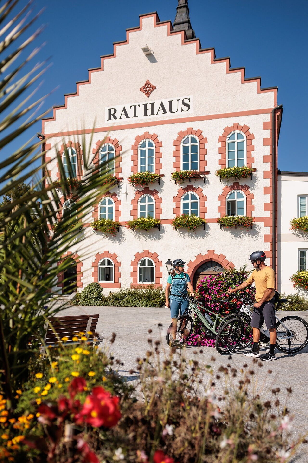 The picturesque backdrop of the town hall in Waidhofen invites cyclists to take a well-earned break. Colorful flowerbeds frame the square and create an inviting atmosphere that perfectly reflects summer in the mountains.