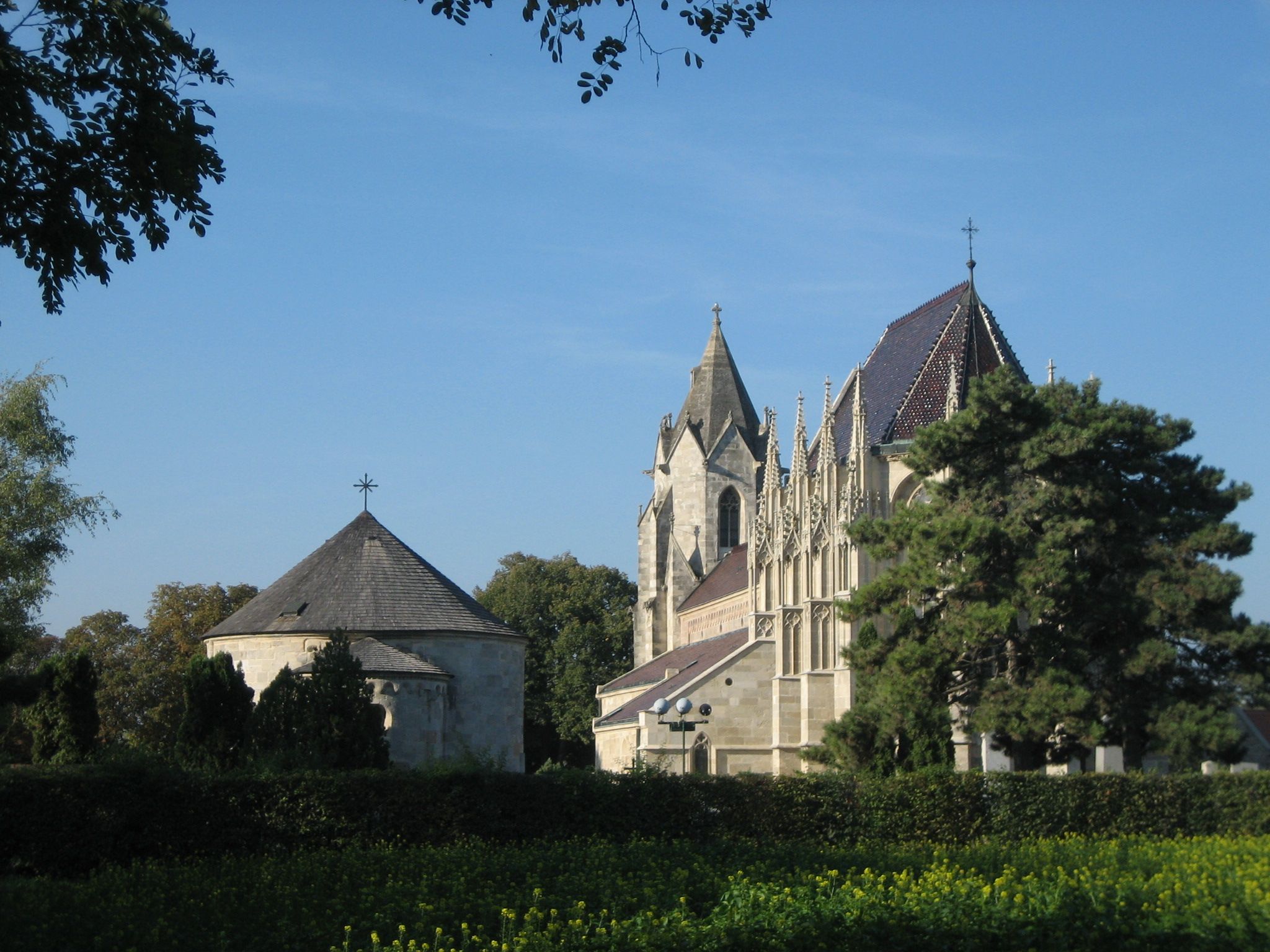 St. Mary's Church in Bad Deutsch-Altenburg with blue sky and trees in the foreground.