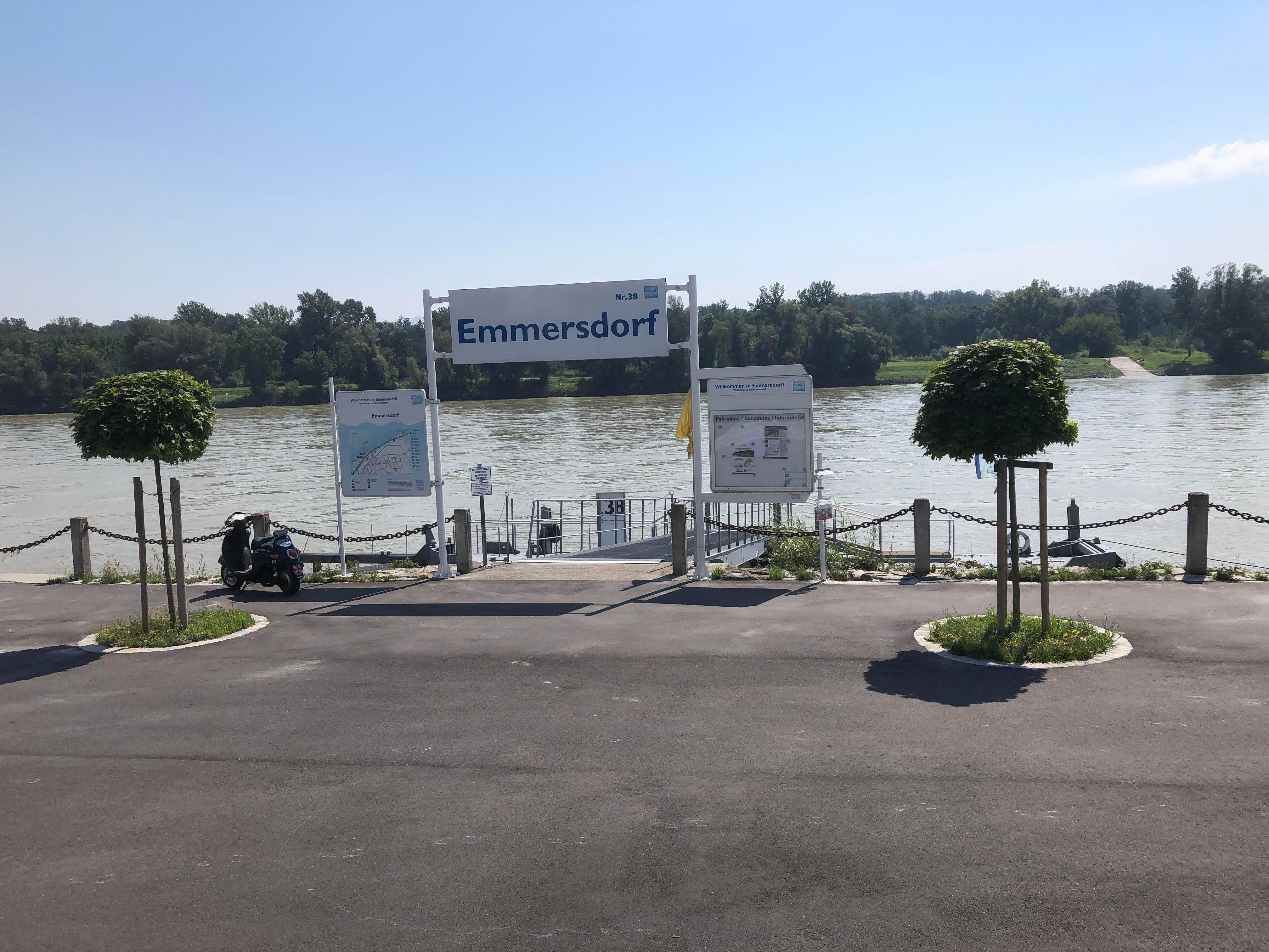 Emmersdorf landing stage on the Danube with signs and trees.