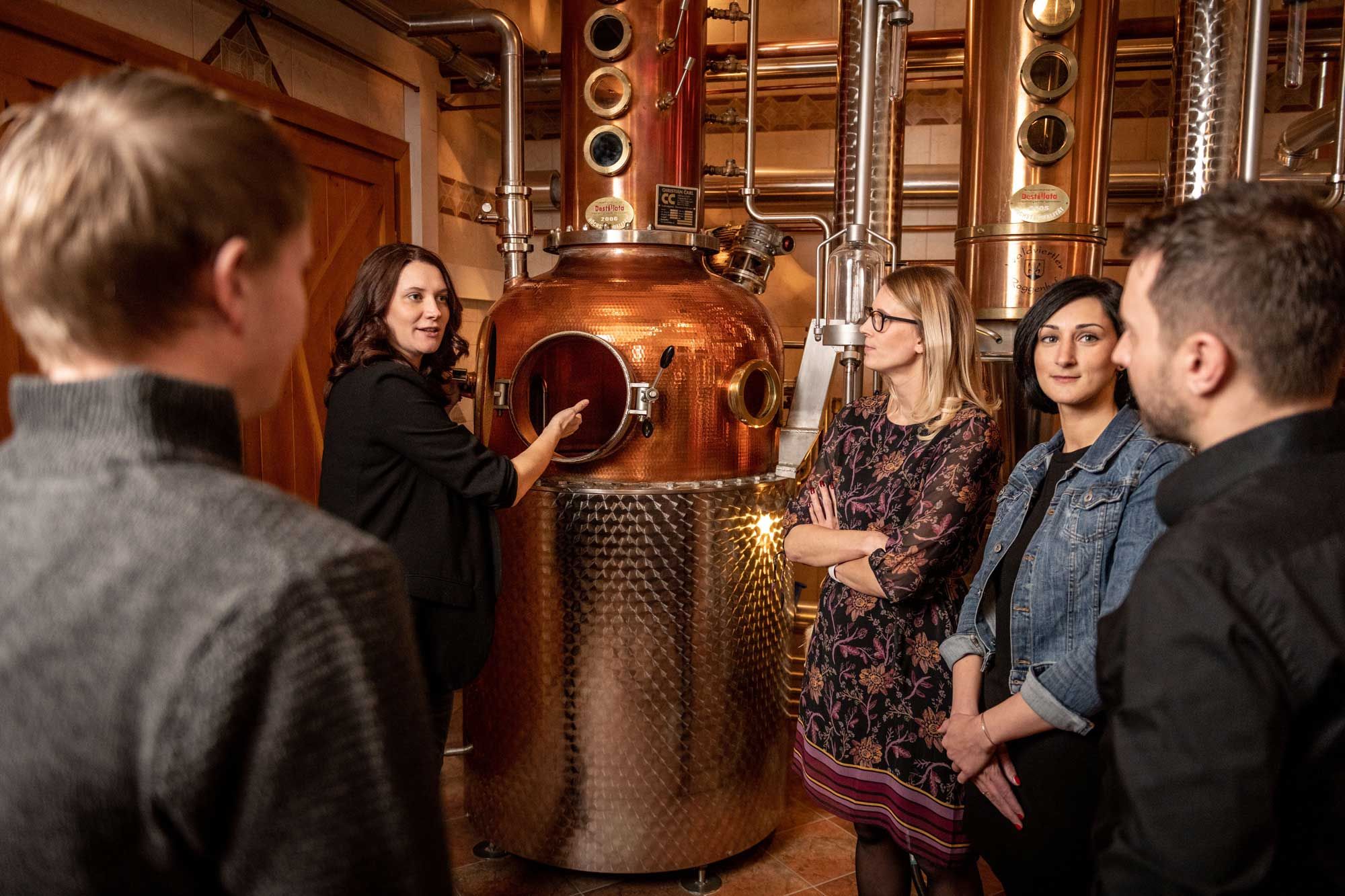 Group of people in a distillery being given a guided tour.