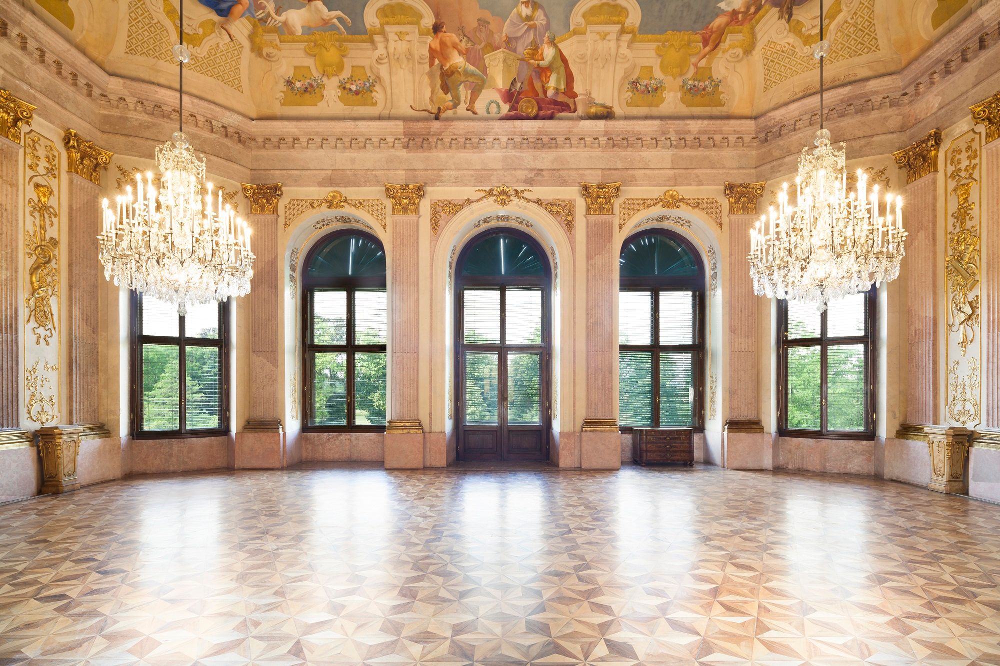 Magnificent ballroom with chandeliers and murals in Eckartsau Castle.