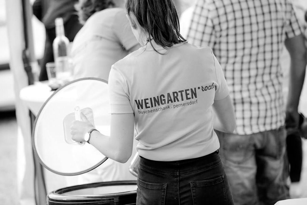 Woman in a T-shirt with the inscription 'Weingarten.rocks' at an event.