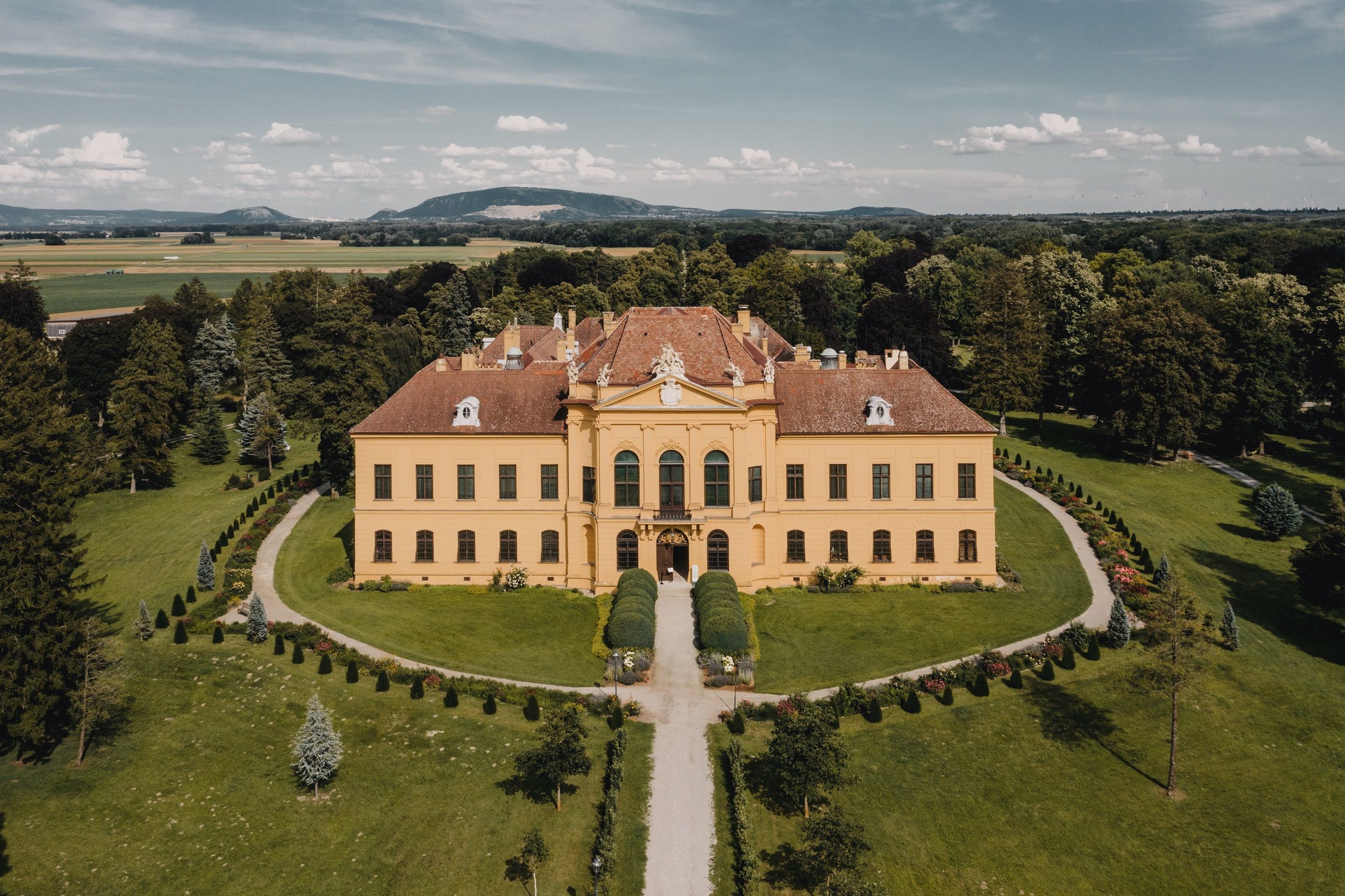 Aerial view of Eckartsau Castle surrounded by green countryside.