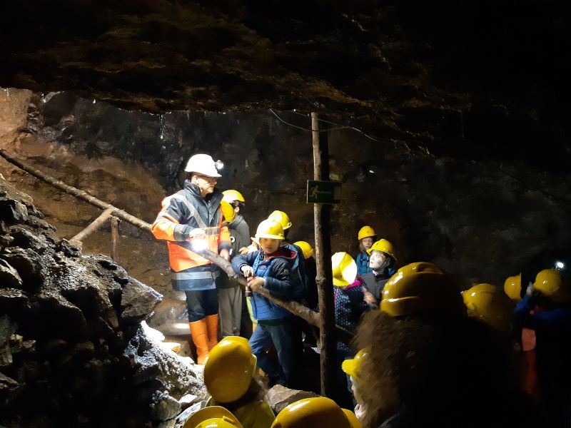 Group of people wearing helmets in a show mine.