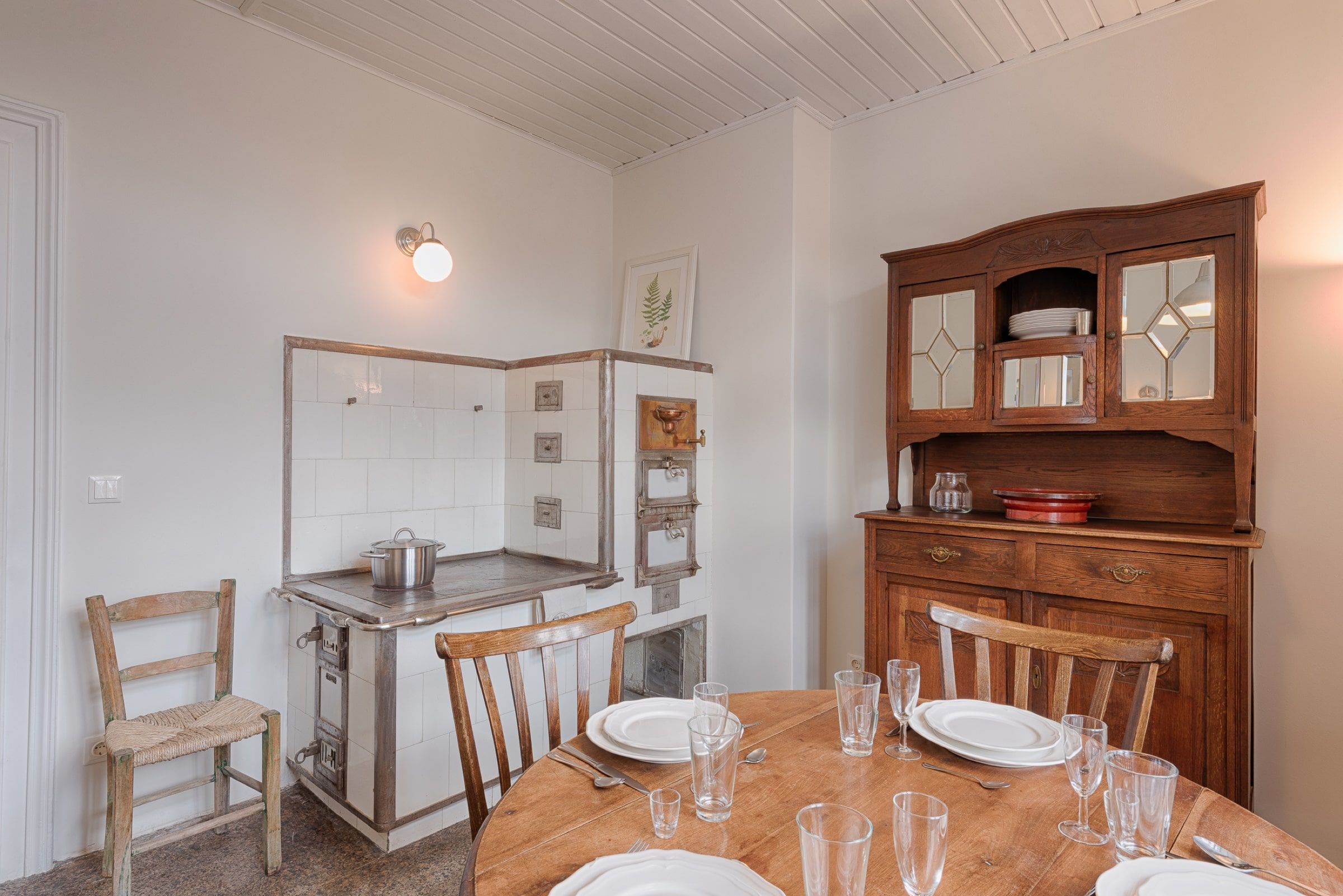 Vintage kitchen with wooden cupboard, old stove and laid table.