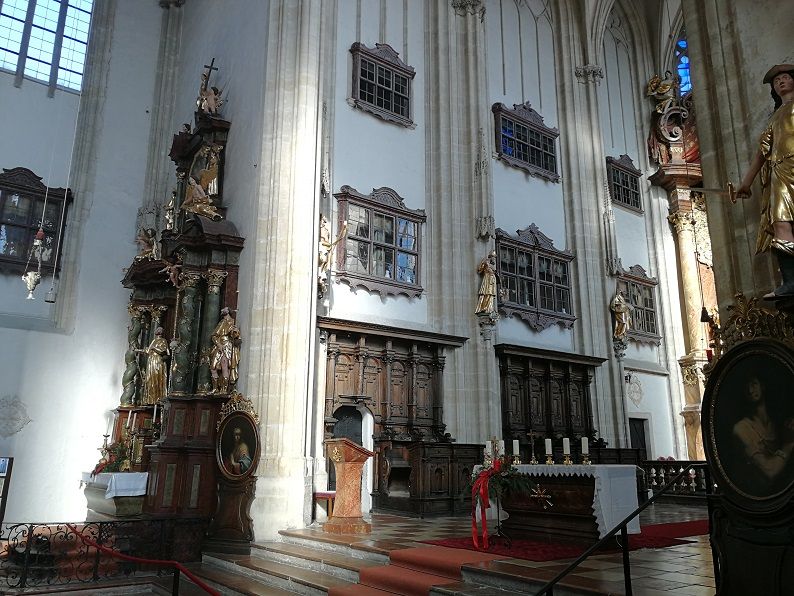 Interior view of the Piarist Church with altar, pulpit and statues.