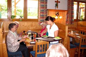 Interior view of a traditional Austrian wine tavern with guests and service.