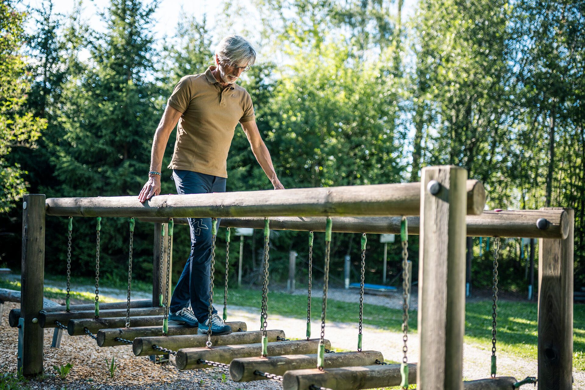 A man is balancing on a wooden obstacle course at the Groß Gerungs Cardiovascular Center in the Waldviertel region.