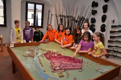 Children look at a model of a city in a museum.