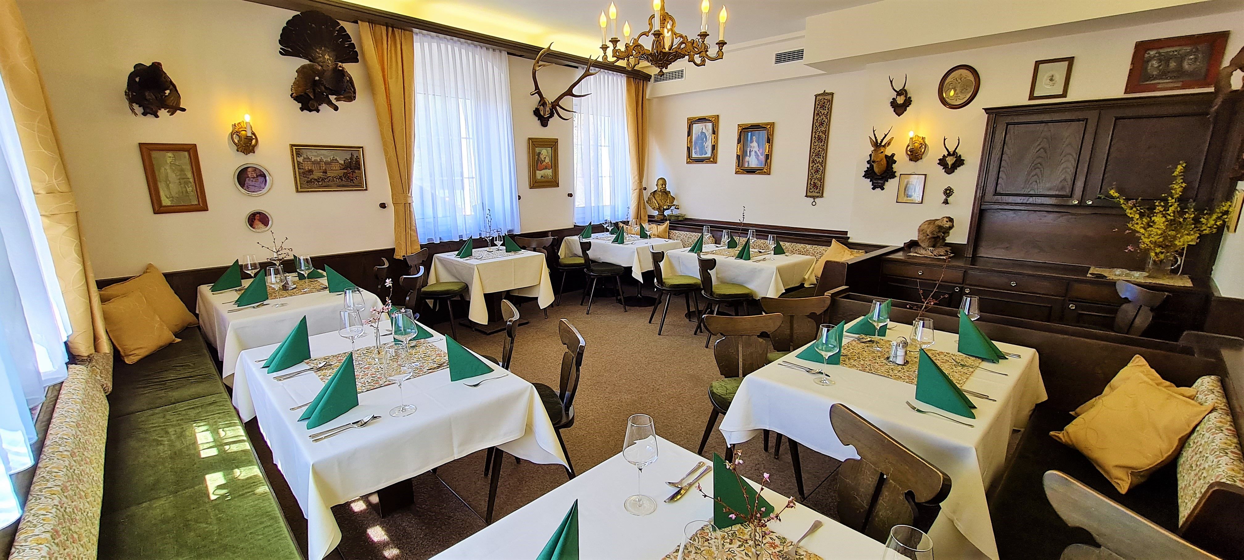 A traditionally decorated dining room with hunting trophies on the walls and laid tables.