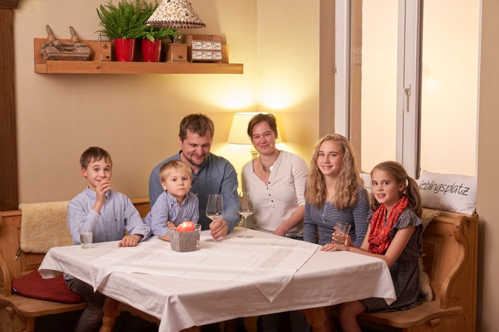 Family sitting at a table in a cozy room.