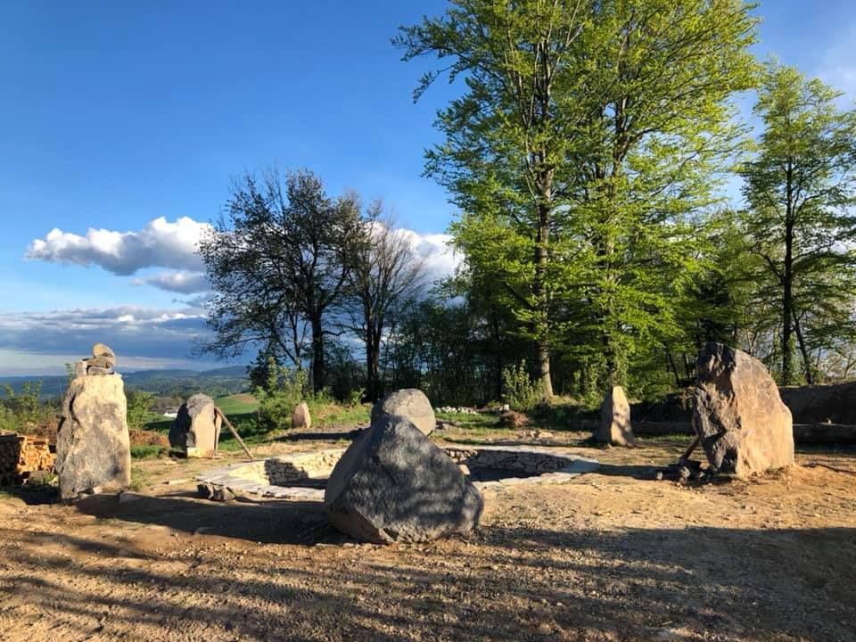 Stone circle in a forest clearing at sunset.