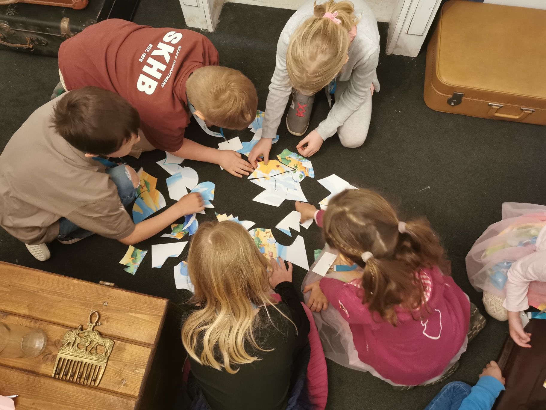 Children sit on the floor and solve a puzzle 
