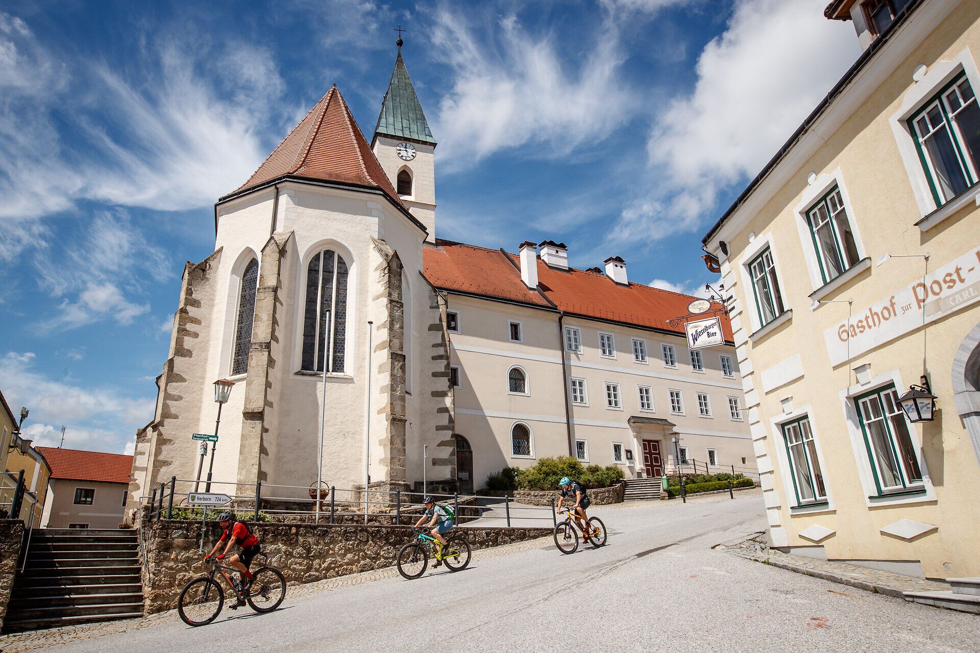 The rolling hills invite you to an unforgettable adventure, while the picturesque architecture of the surrounding area provides a harmonious backdrop. Cyclists glide up the road to enjoy the breathtaking views of the surrounding nature. Here, where tradition and nature meet, every moment is an experience.