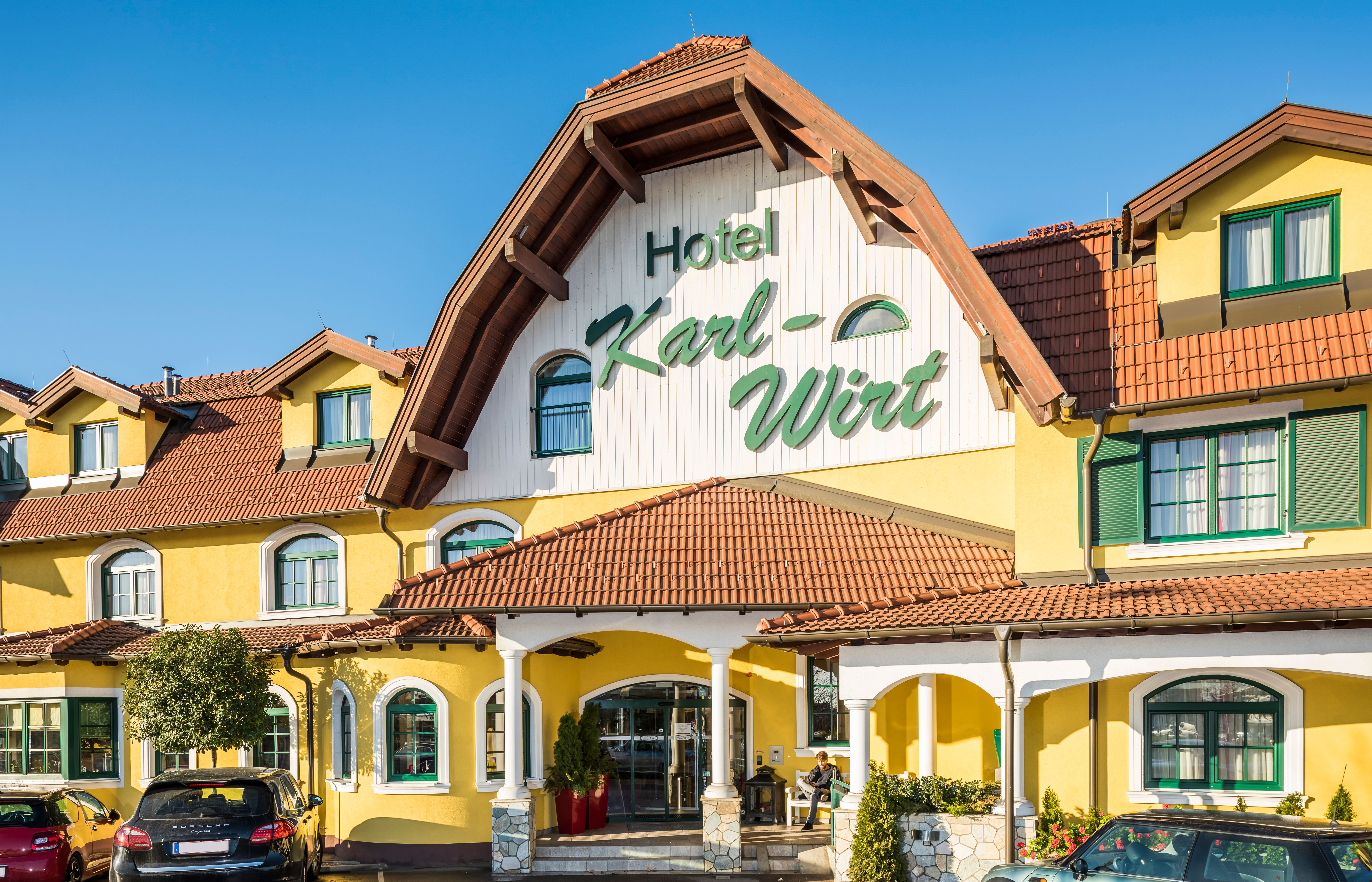 Yellow hotel building with the lettering 'Hotel Karl-Wirt' on the gable.