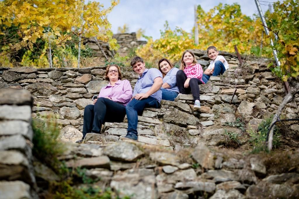 Family sitting on stone steps in the vineyard.