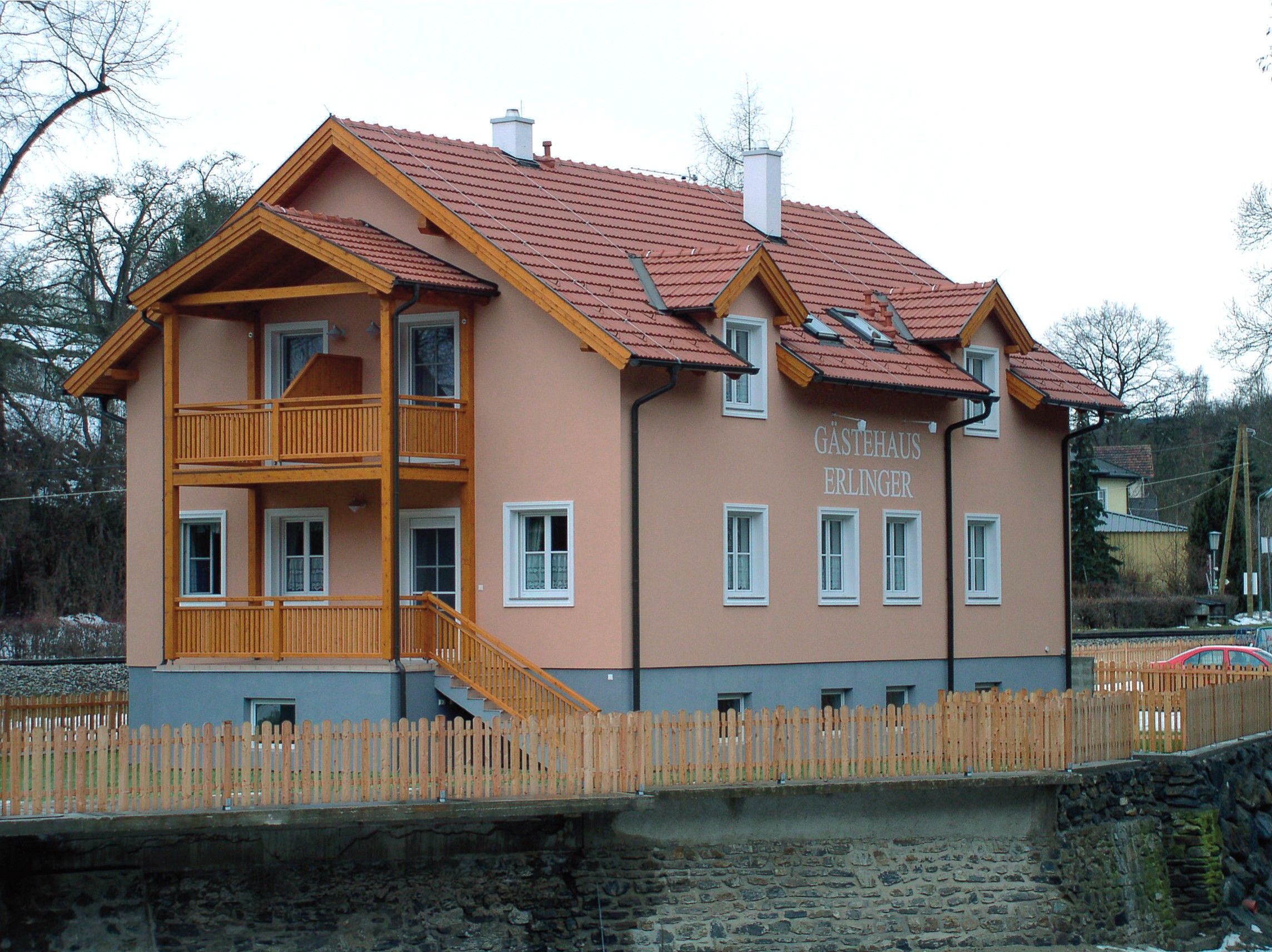 Erlinger guest house with wooden veranda and fence.