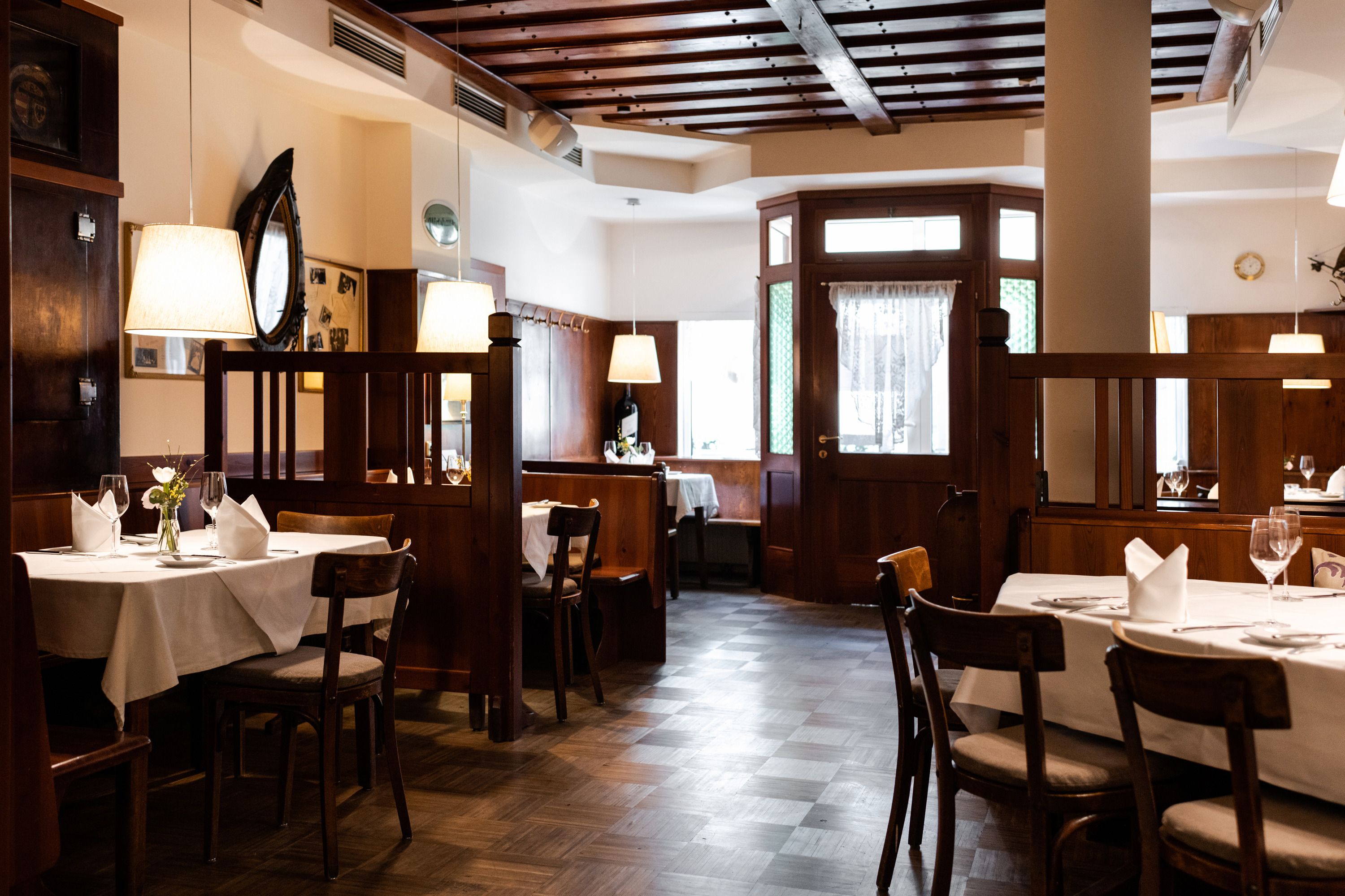 Cozy restaurant with wooden furniture and laid tables.