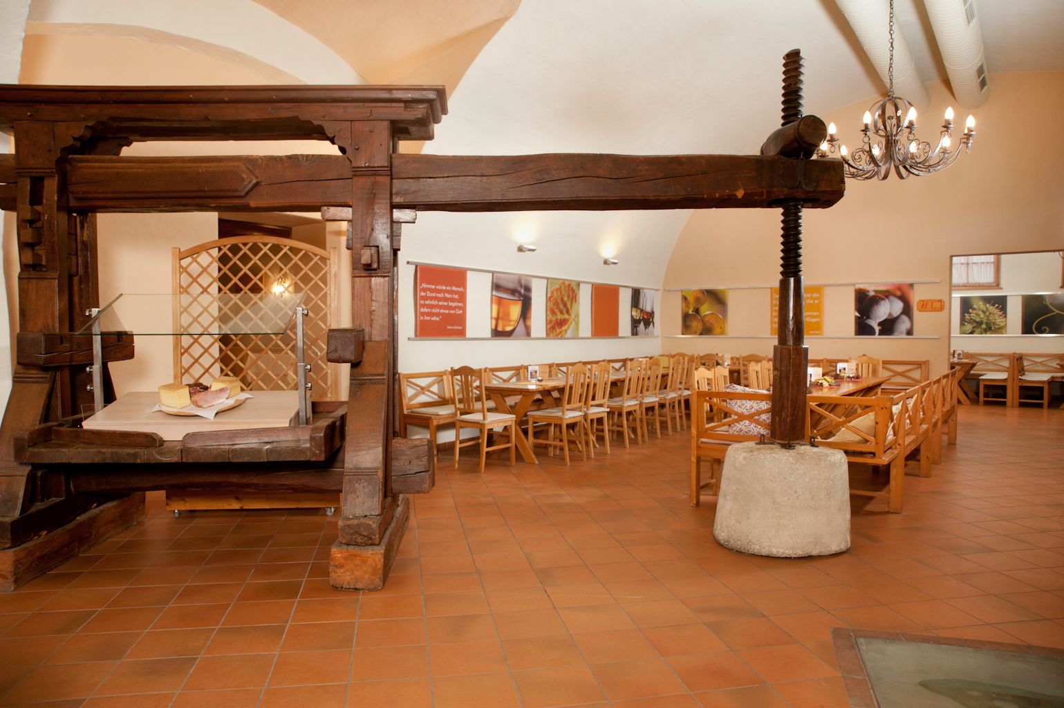 Interior view of a traditional wine tavern with wooden furniture and an old wine press.