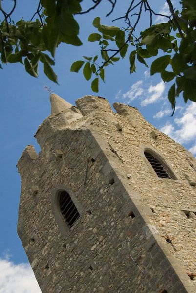 Scharndorf fortified church with blue sky and leaves in the foreground.