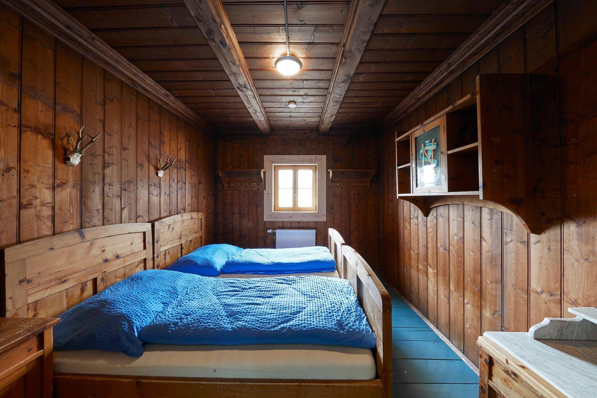 Rustic bedroom with wood paneling and double bed.
