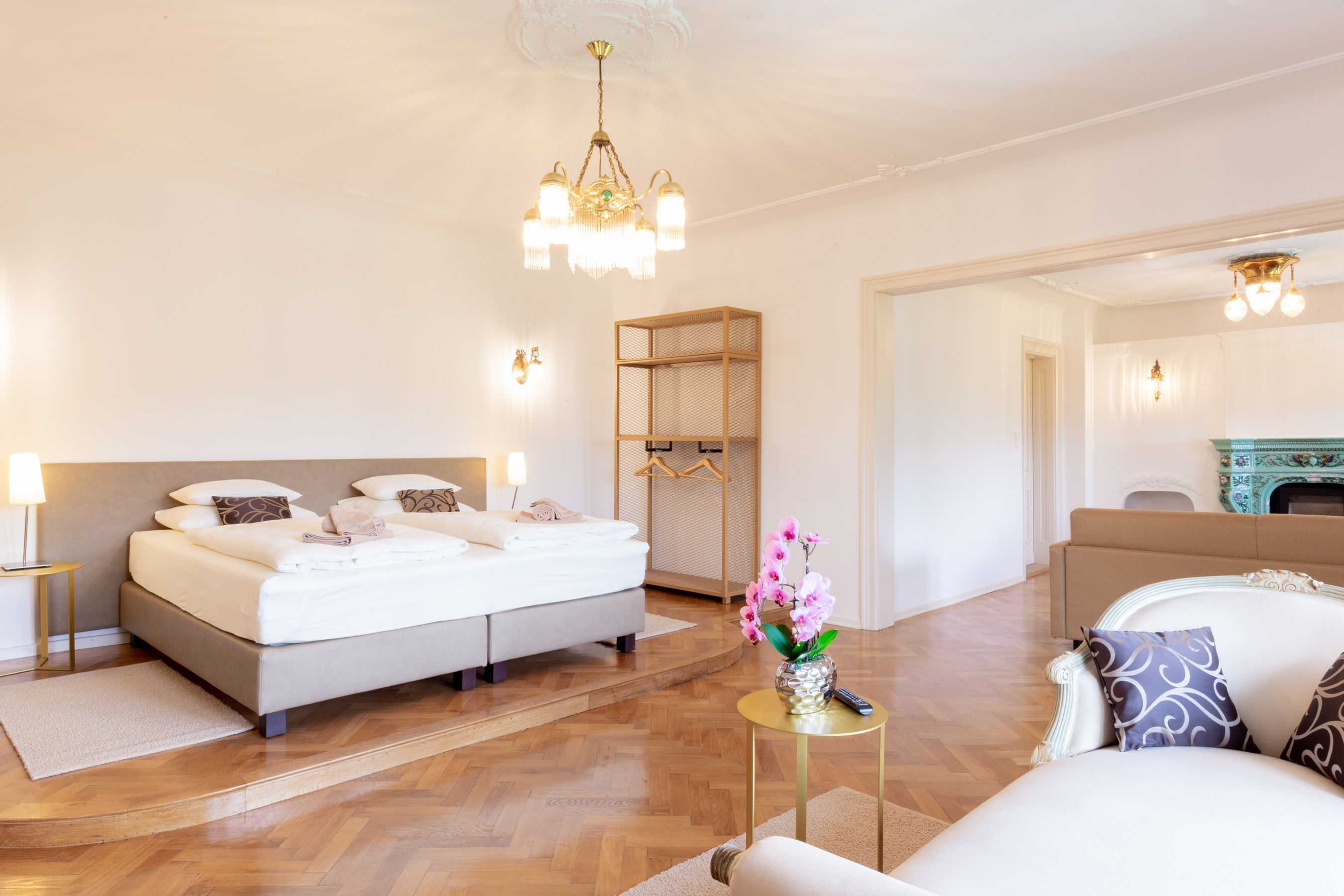 Elegant bedroom with double bed, chandelier and fireplace.