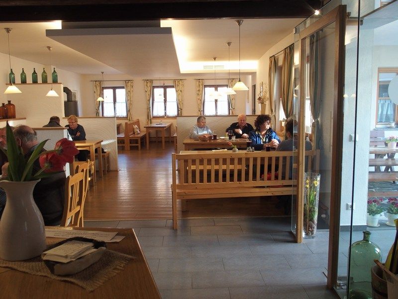 Interior view of a cozy wine tavern with wooden furniture and guests at tables.