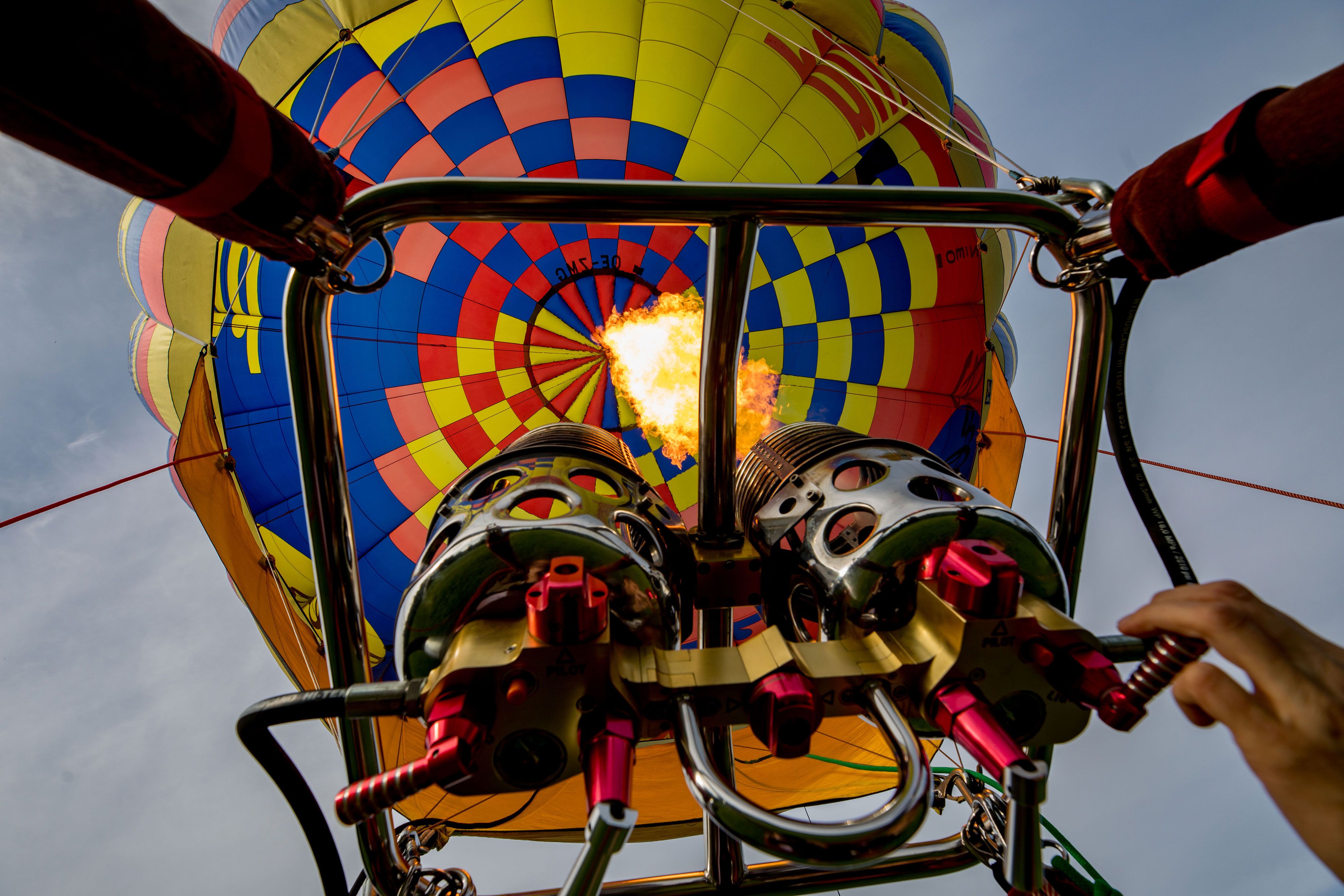 View from below of a hot air balloon with a burning burner.