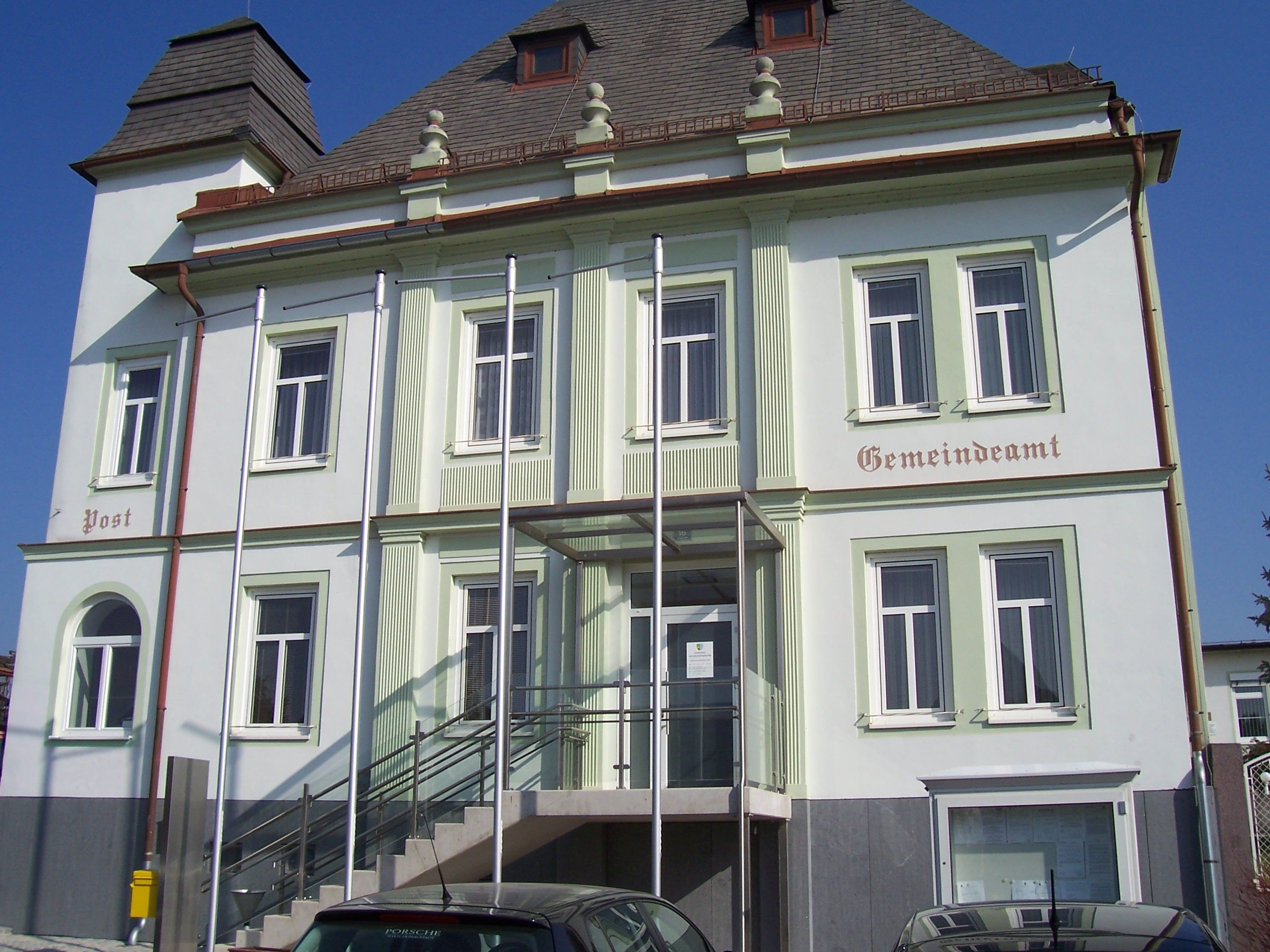 Untersiebenbrunn municipal office with stairs and flagpoles in front of the building.