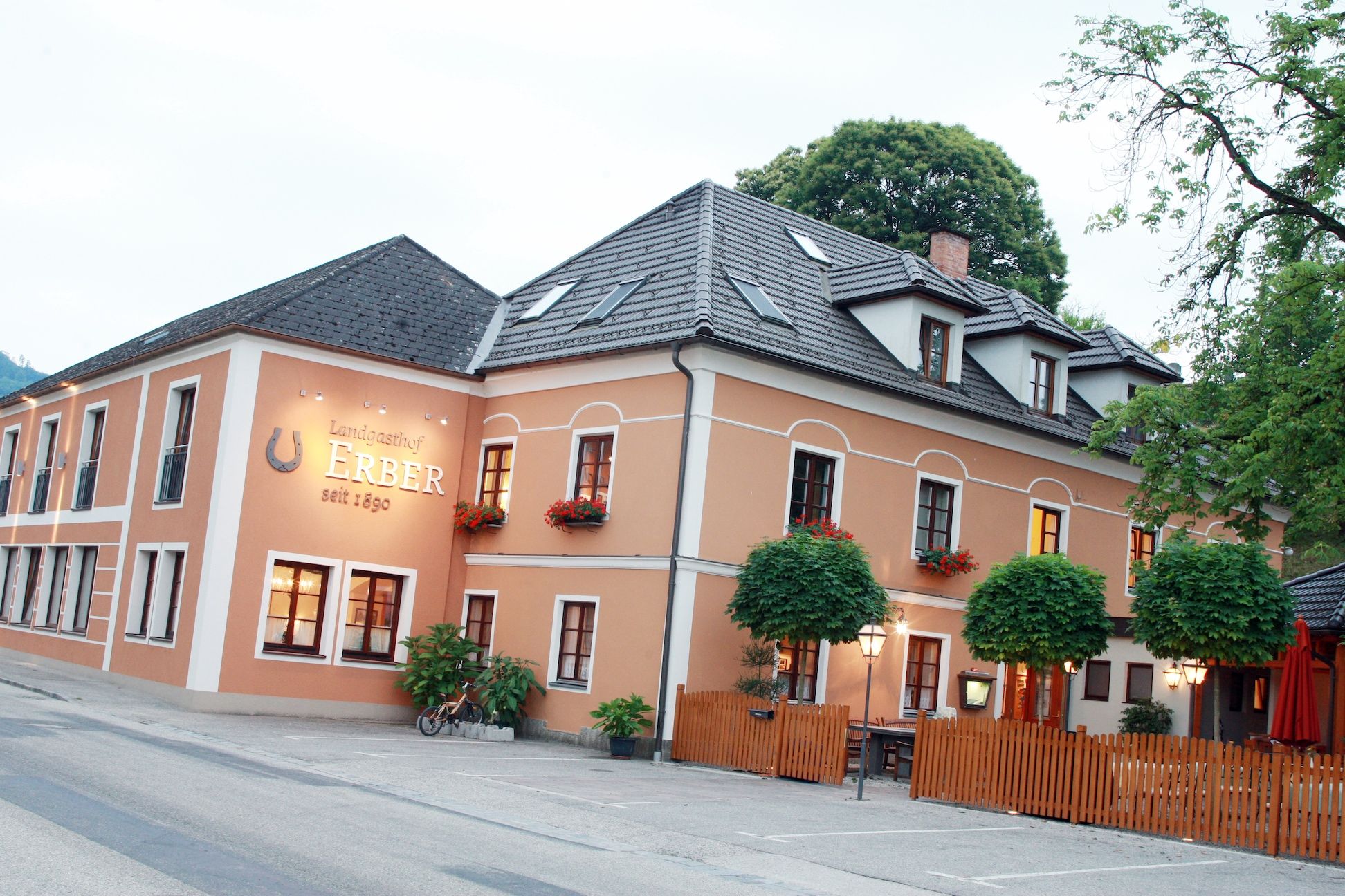 Exterior view of the Landgasthof Erber with orange facade and flower boxes.