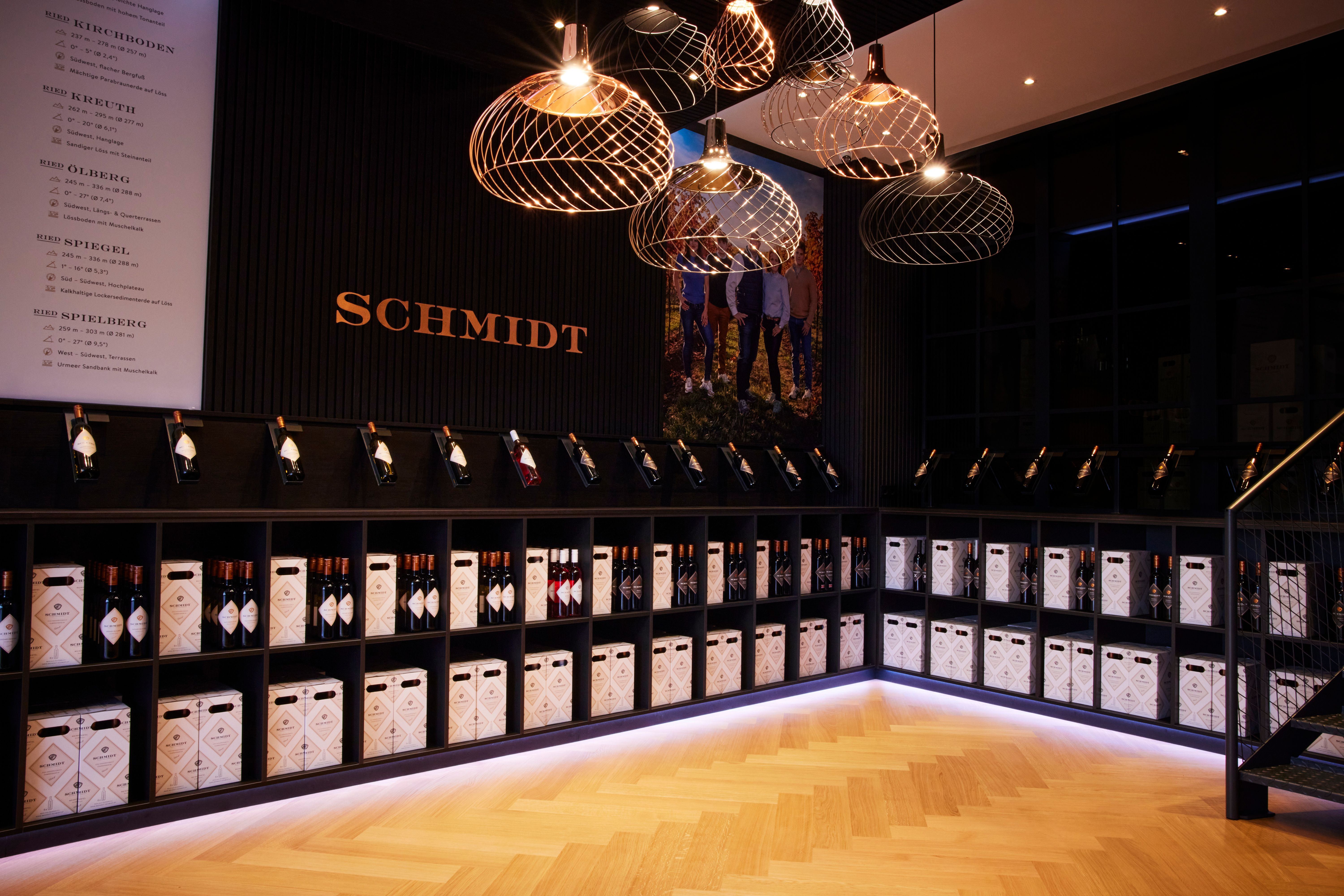 Wine rack with bottles and boxes in a stylish room with the lettering 'Schmidt'.