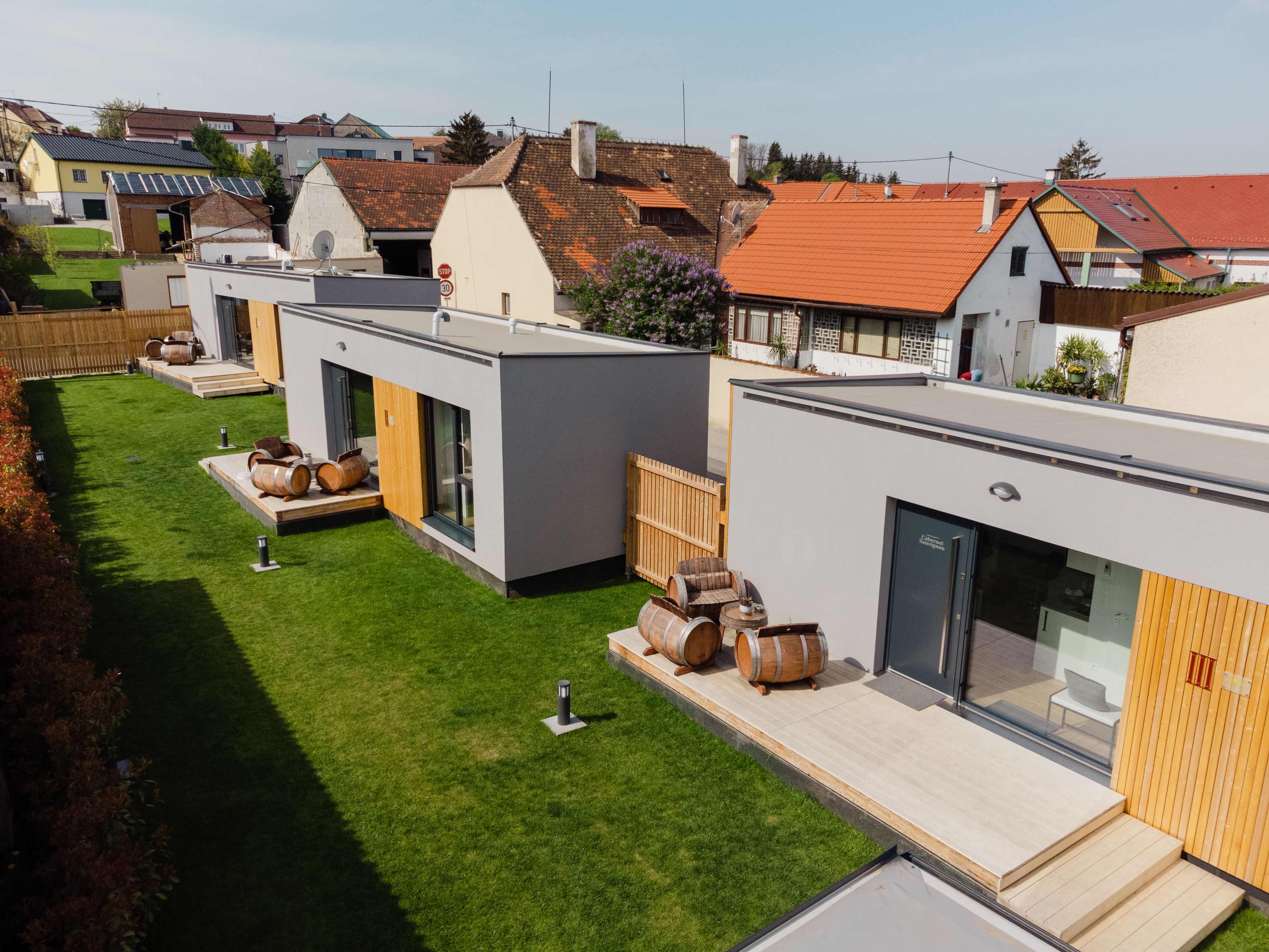 Modern apartments with wooden barrel decoration on a green meadow.