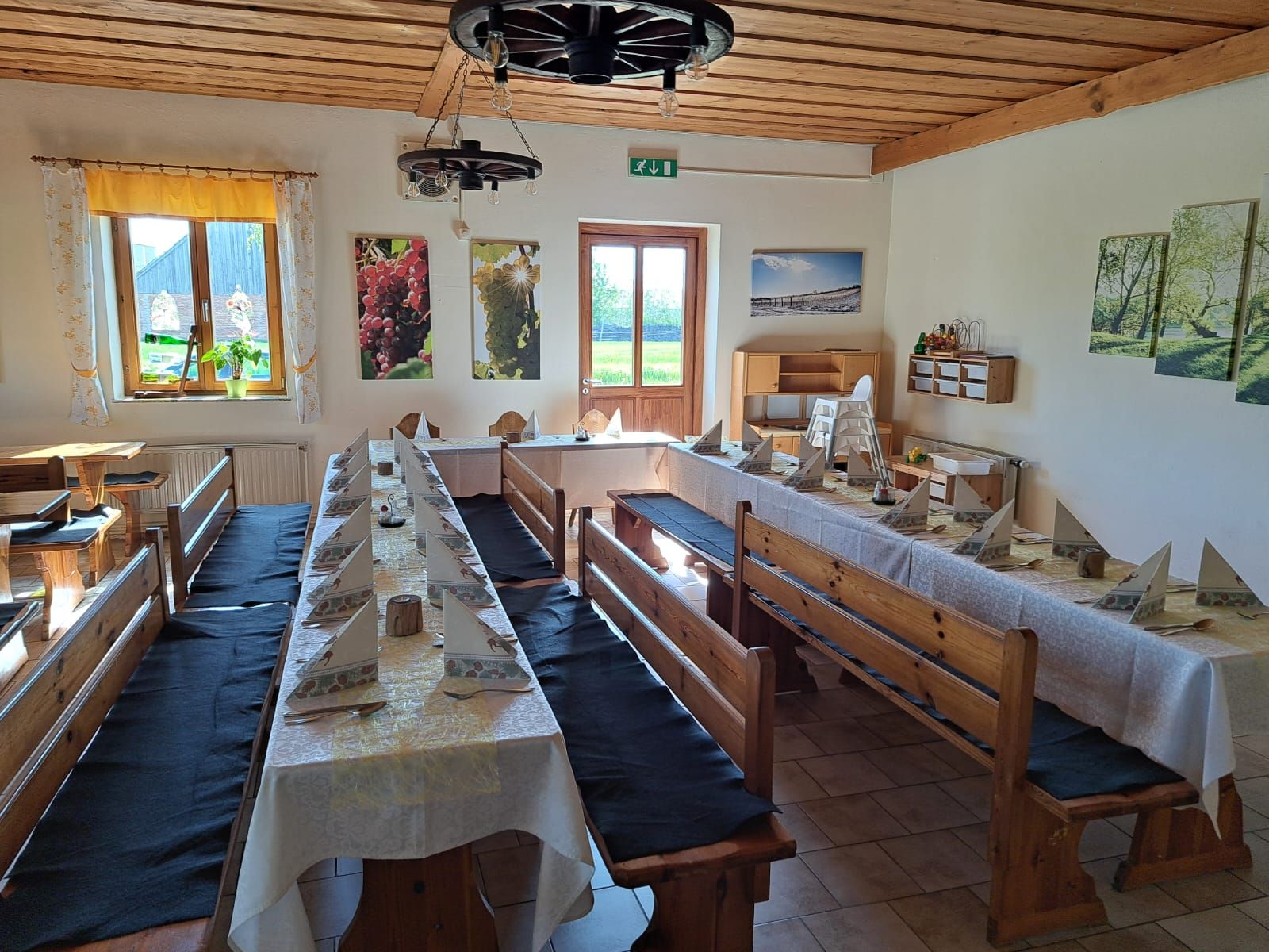 Interior view of a rustic dining room with wooden benches and laid tables.